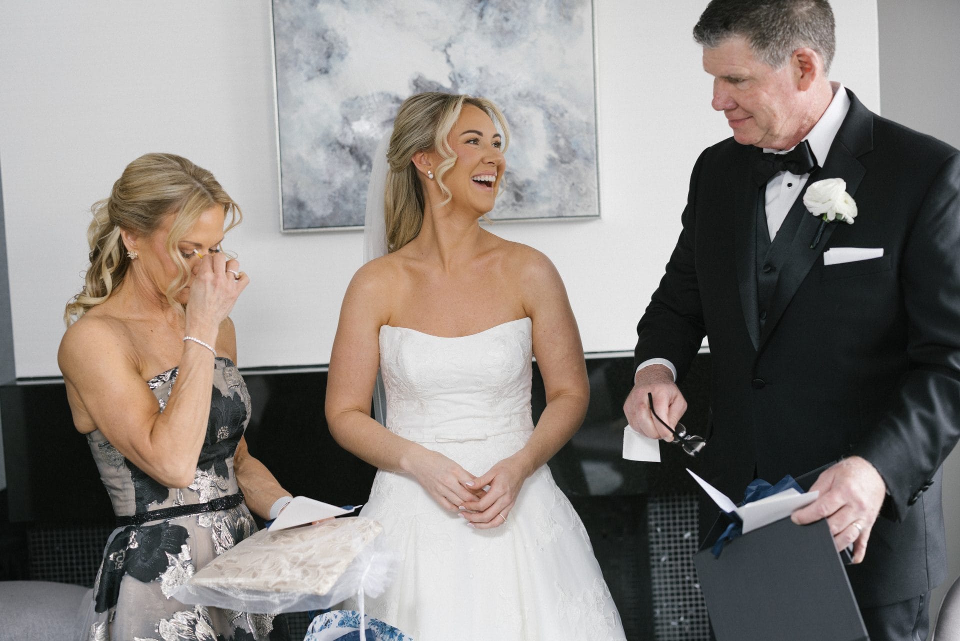 Father of the bride reading card while mother cries during gift exchange
