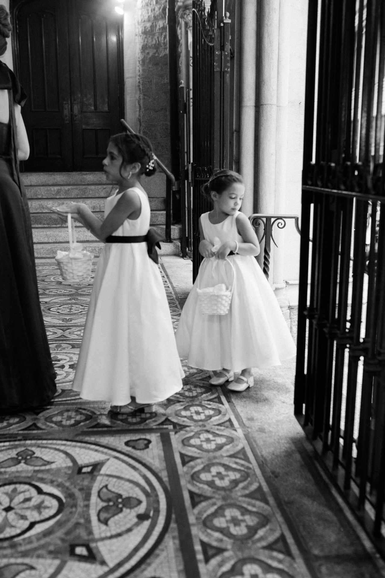 Two flower girls inside church entrance with baskets at Philadelphia Catholic wedding