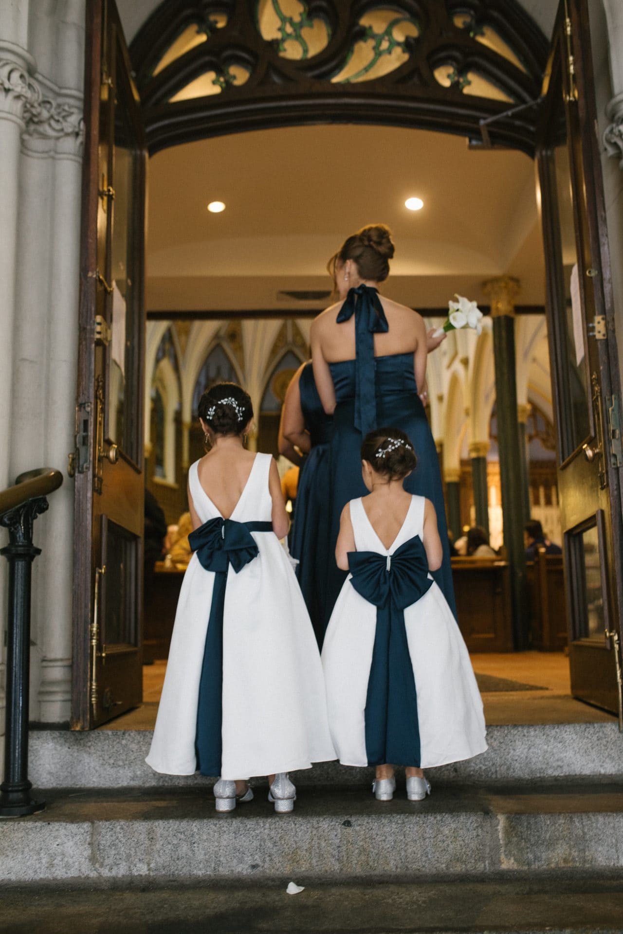 Bridesmaid and flower girls entering St John the Evangelist Church for wedding ceremony
