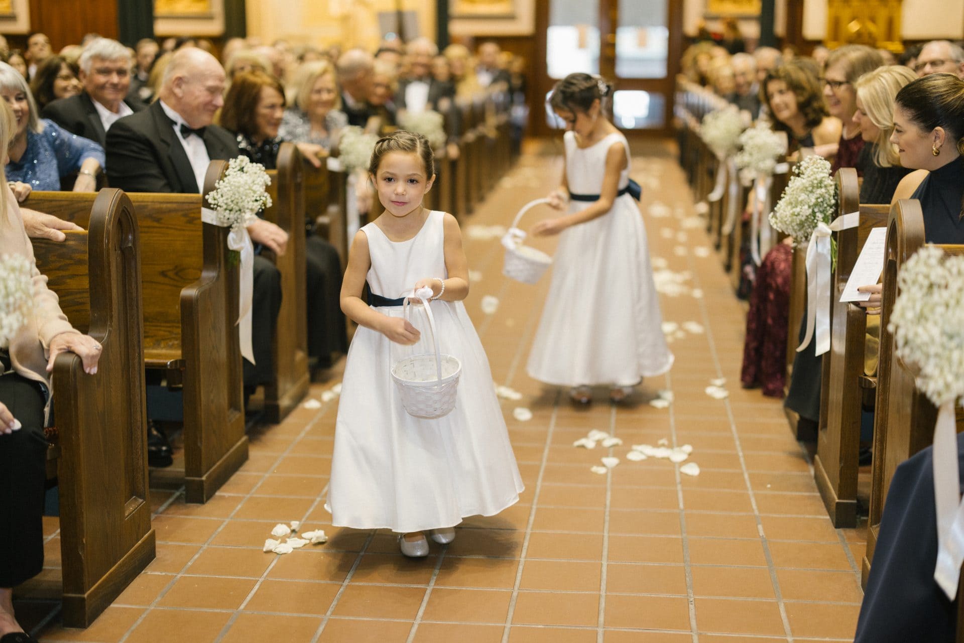 Flower girls walking down church aisle dropping petals at Philadelphia wedding