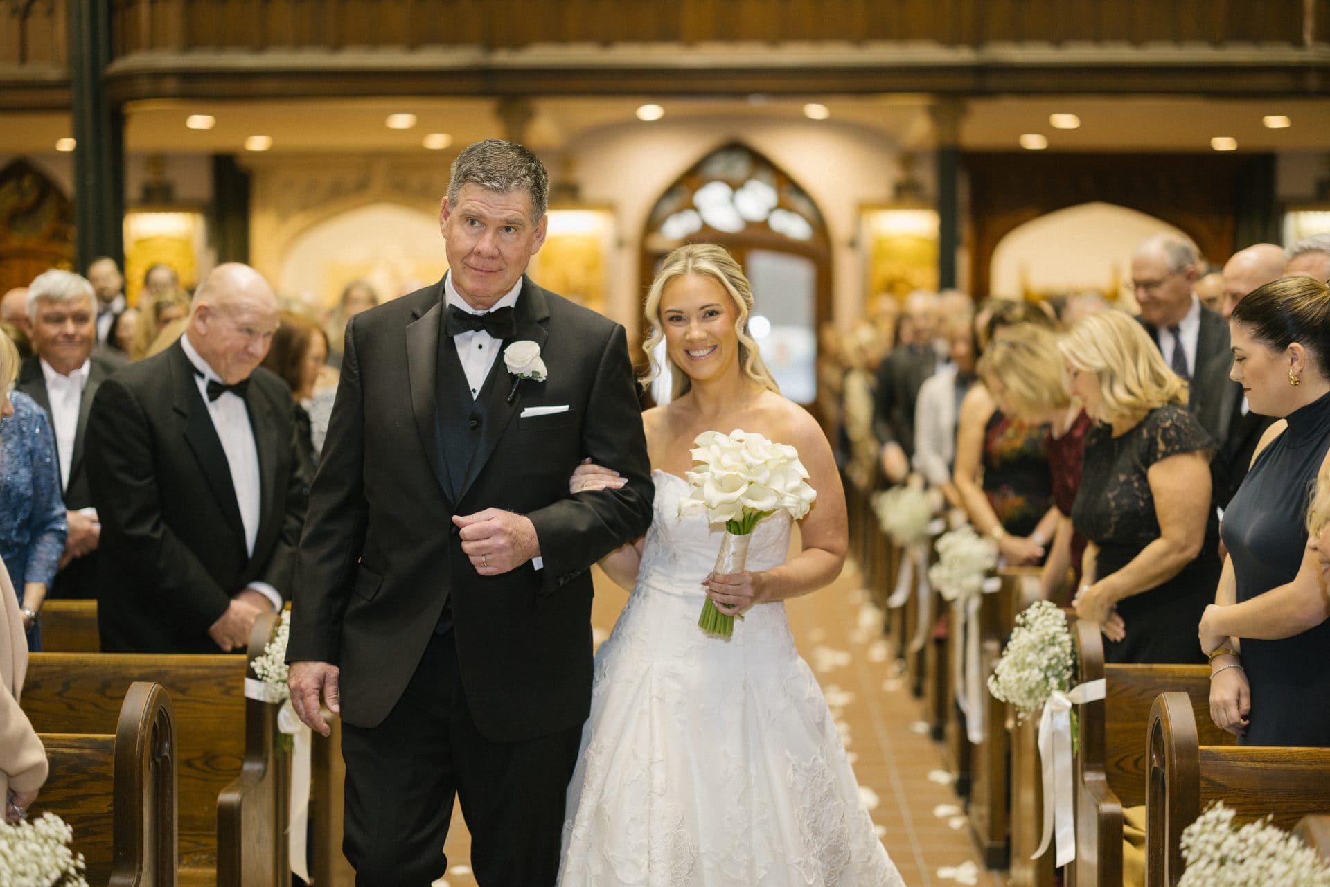 Father walking bride down aisle surrounded by guests at St John the Evangelist Church