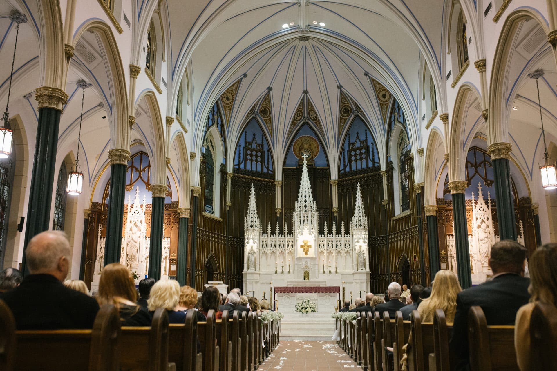 Full church interior during wedding ceremony blue vaulted ceiling gothic altar St John the Evangelist