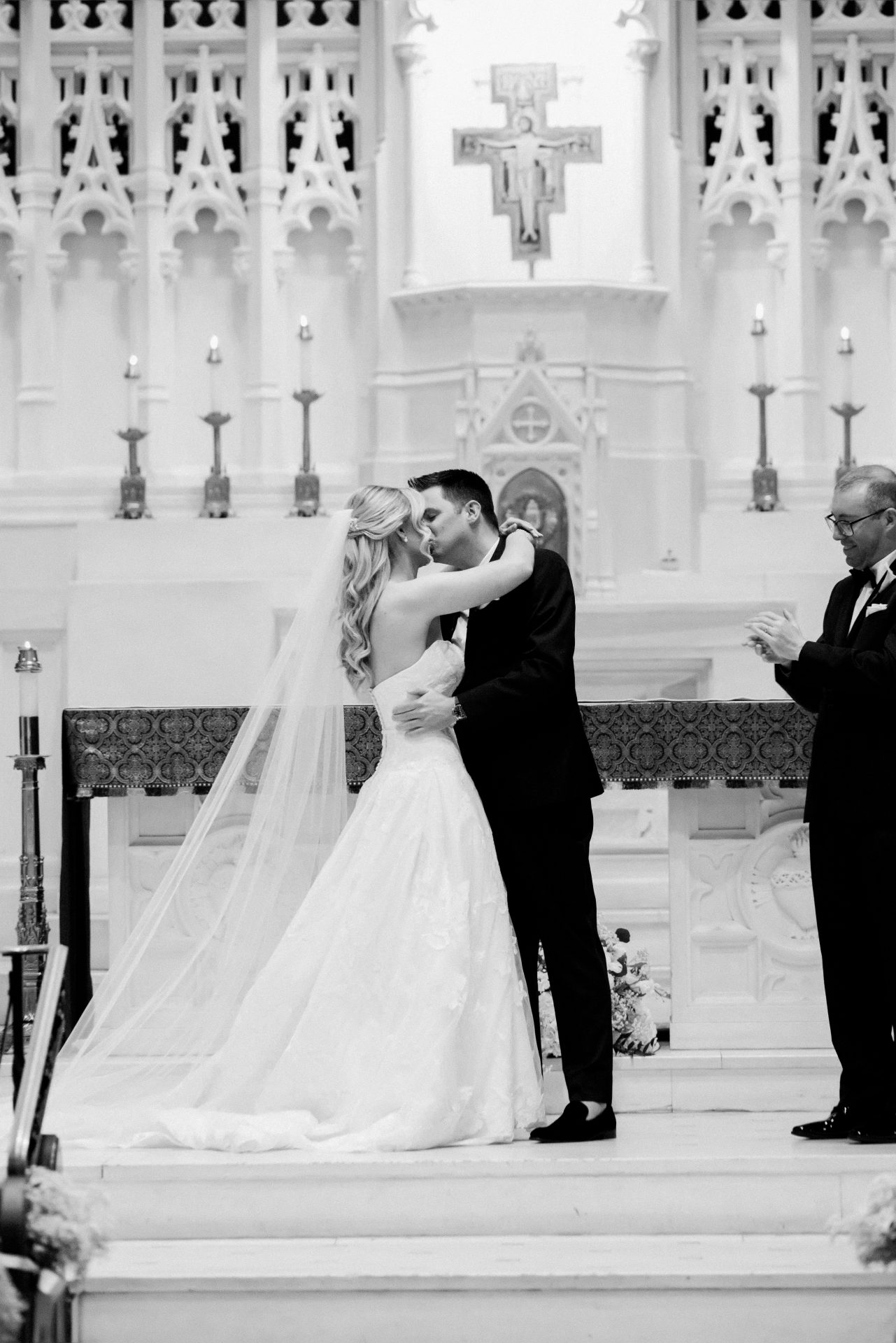 First kiss at the altar in black and white at St John the Evangelist Catholic Church