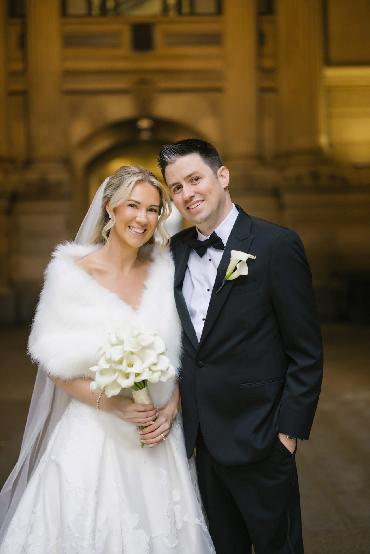 Bride and groom close up portrait at City Hall holding calla lily bouquet
