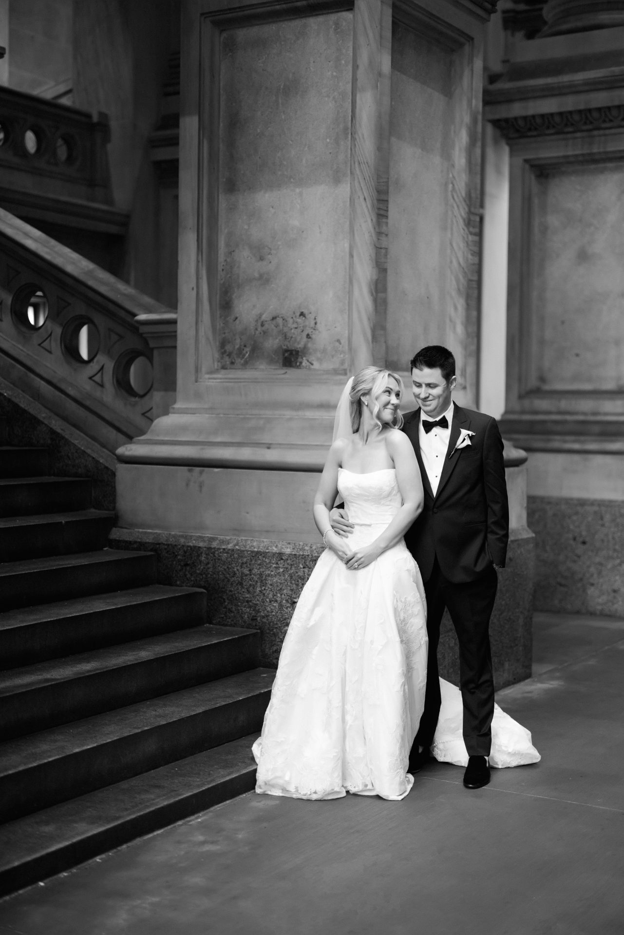 Couple at City Hall grand staircase full length wedding gown portrait