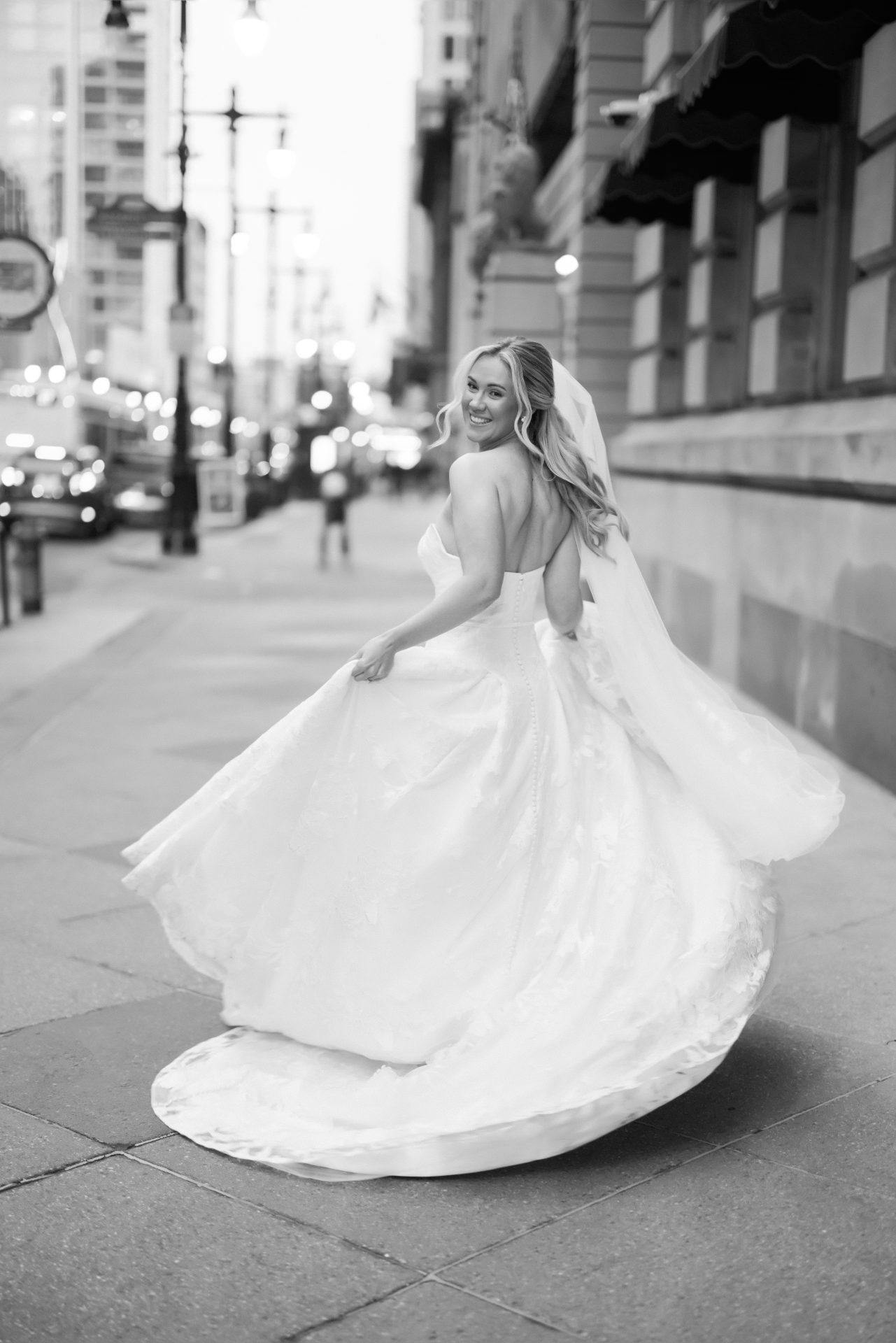Bride spinning on Philadelphia sidewalk dress flowing solo bridal portrait