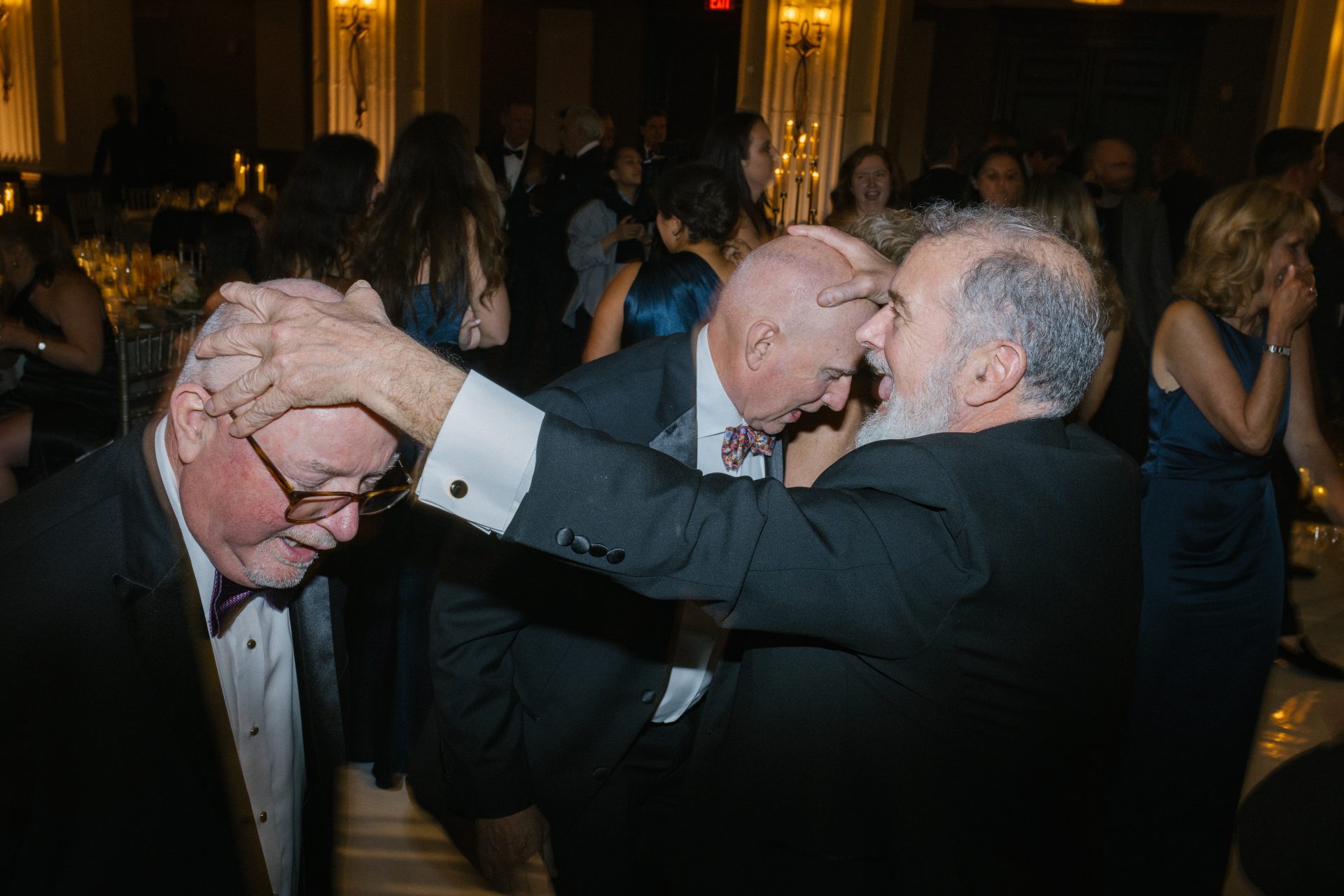 Guests embracing and laughing at Ballroom at the Ben wedding reception