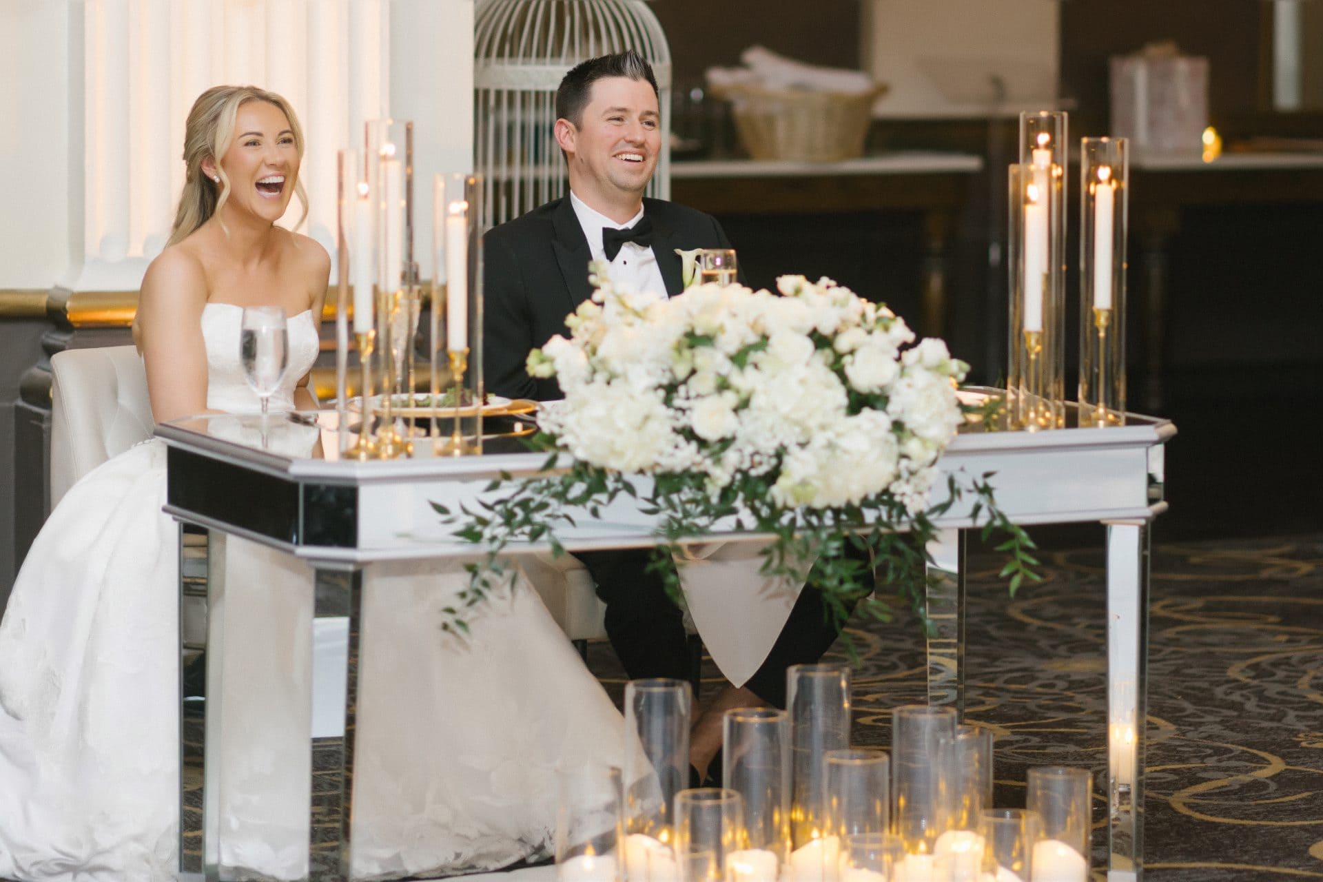 Couple laughing at sweetheart table during toasts Ballroom at the Ben wedding
