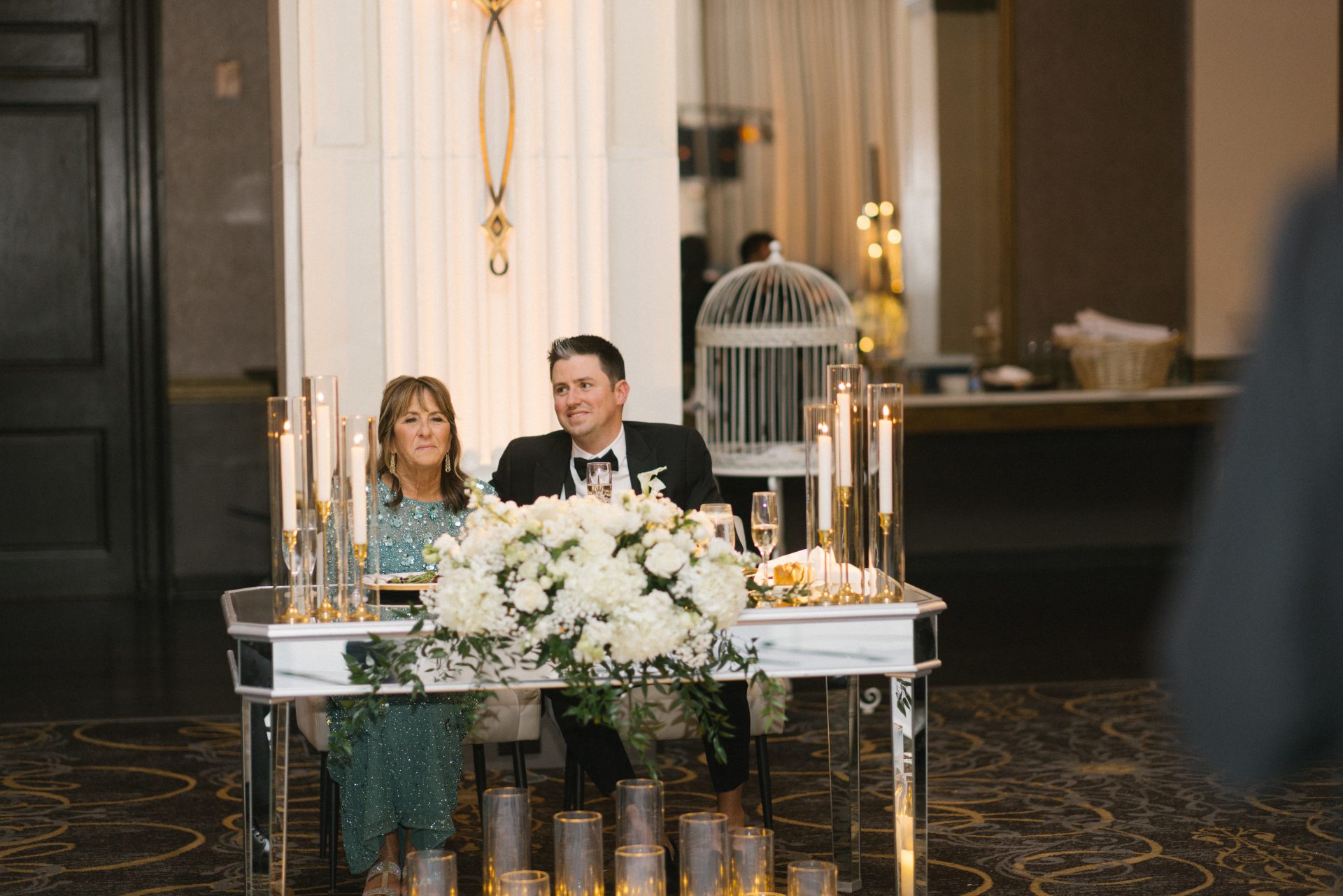Grooms mother seated next to groom during toasts at Ballroom at the Ben