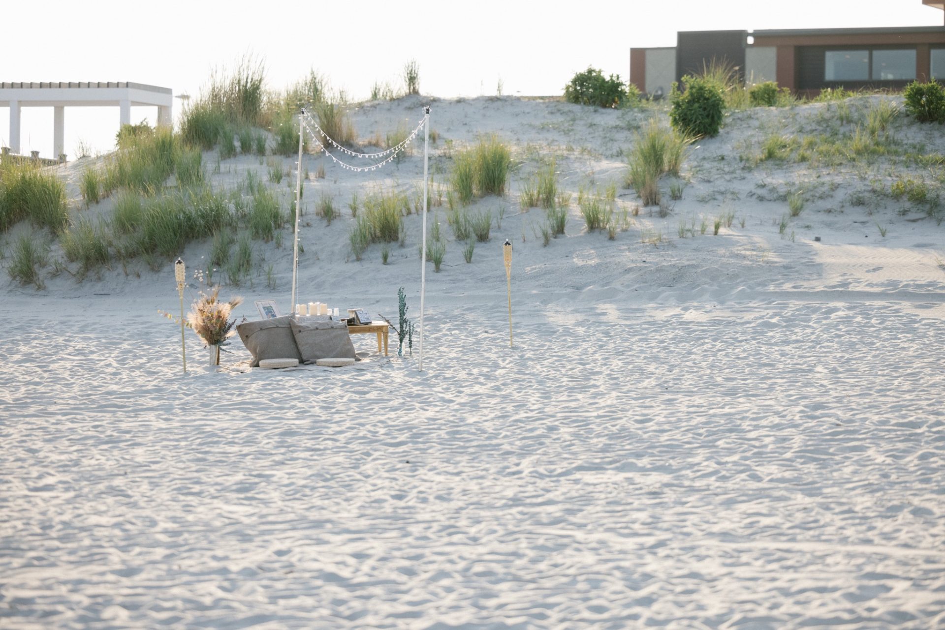 Beach proposal backdrop with flowers set up at ICONA Avalon beach in Avalon NJ