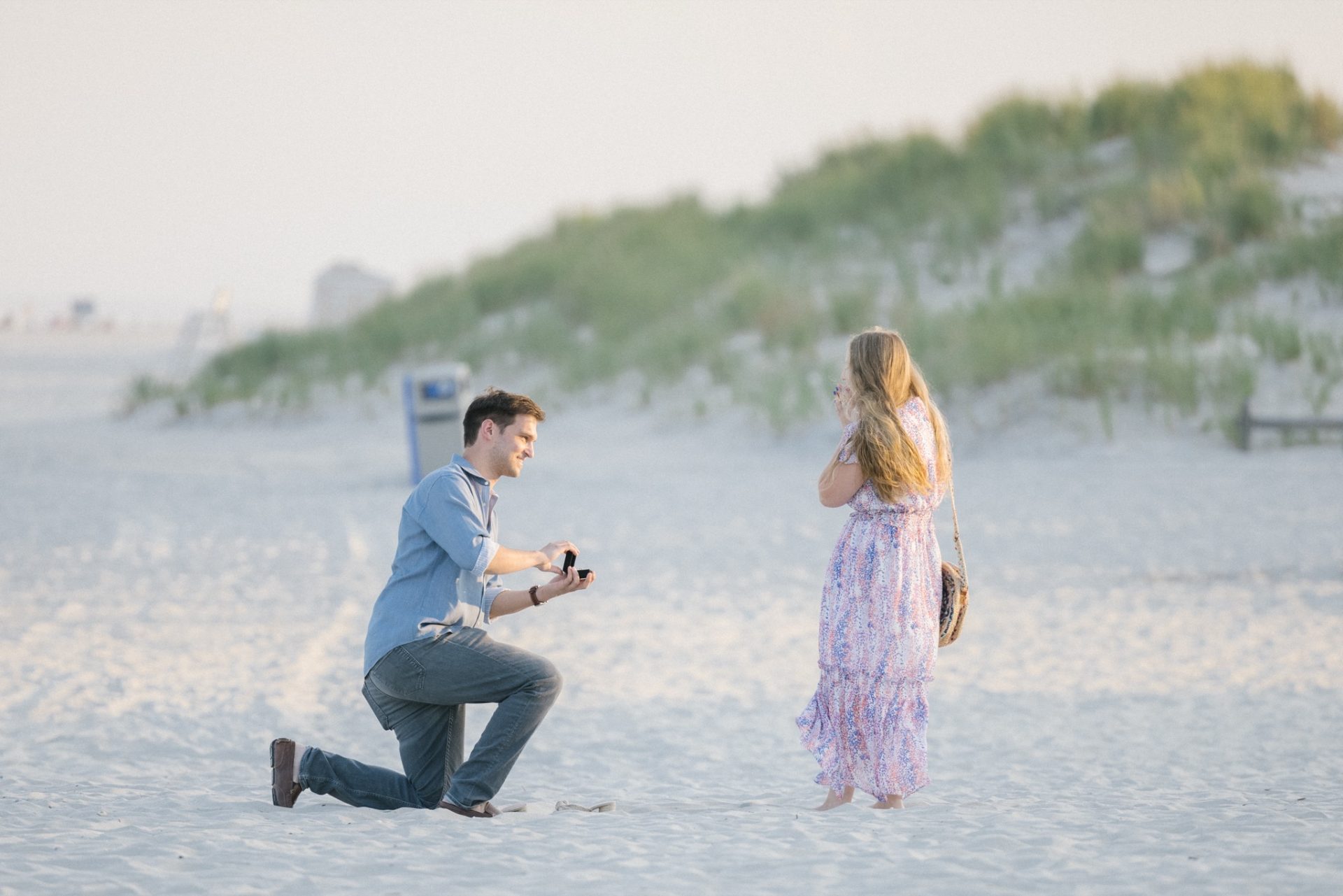 Newly engaged couple popping champagne on Avalon NJ beach after ICONA Avalon proposal