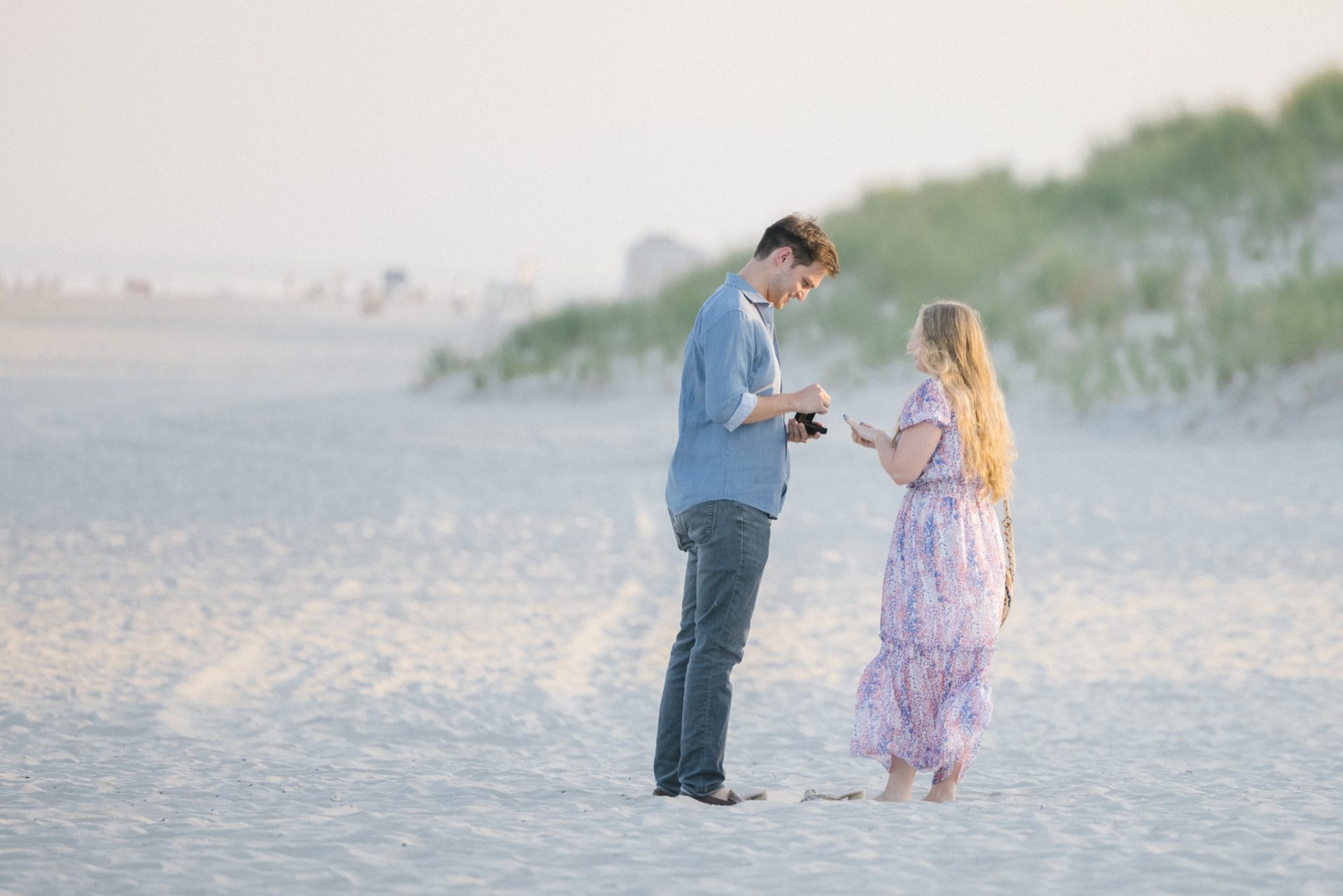 Family group photo after beach proposal at ICONA Avalon with sunset sky behind them