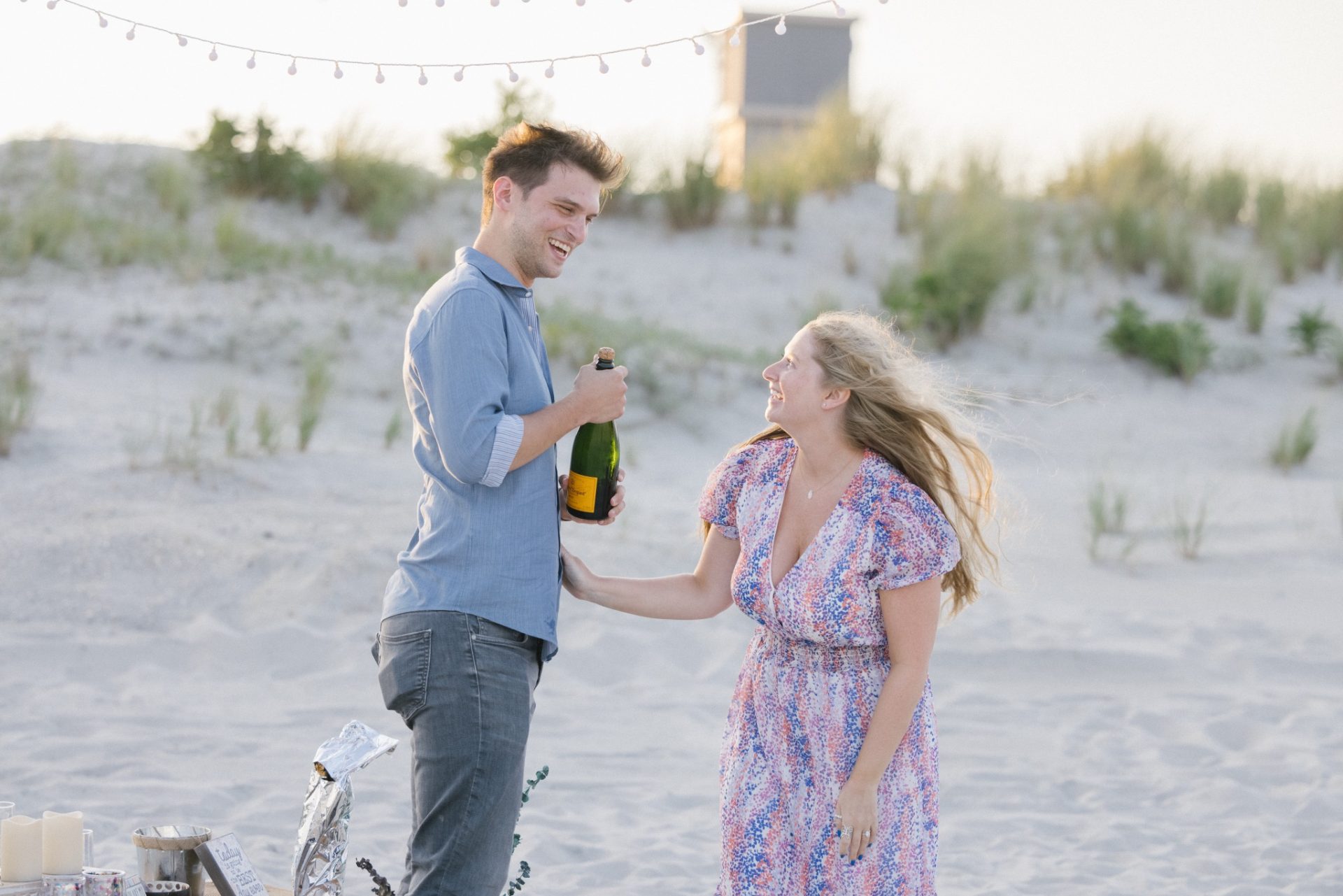Romantic portrait of engaged couple walking on Avalon NJ beach at golden hour