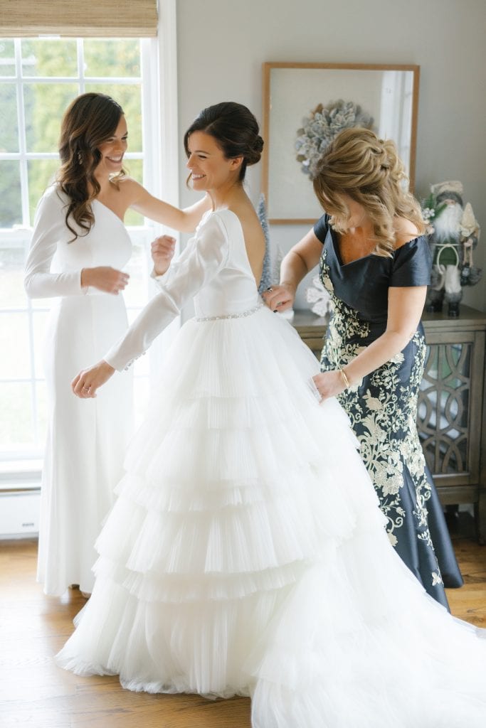 Bride getting ready, putting on earring before her wedding
