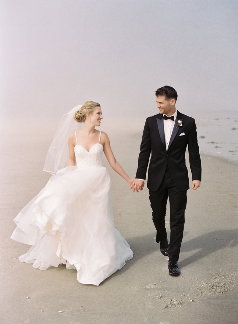 Kellie and Karl walking together on the beach at ICONA Avalon