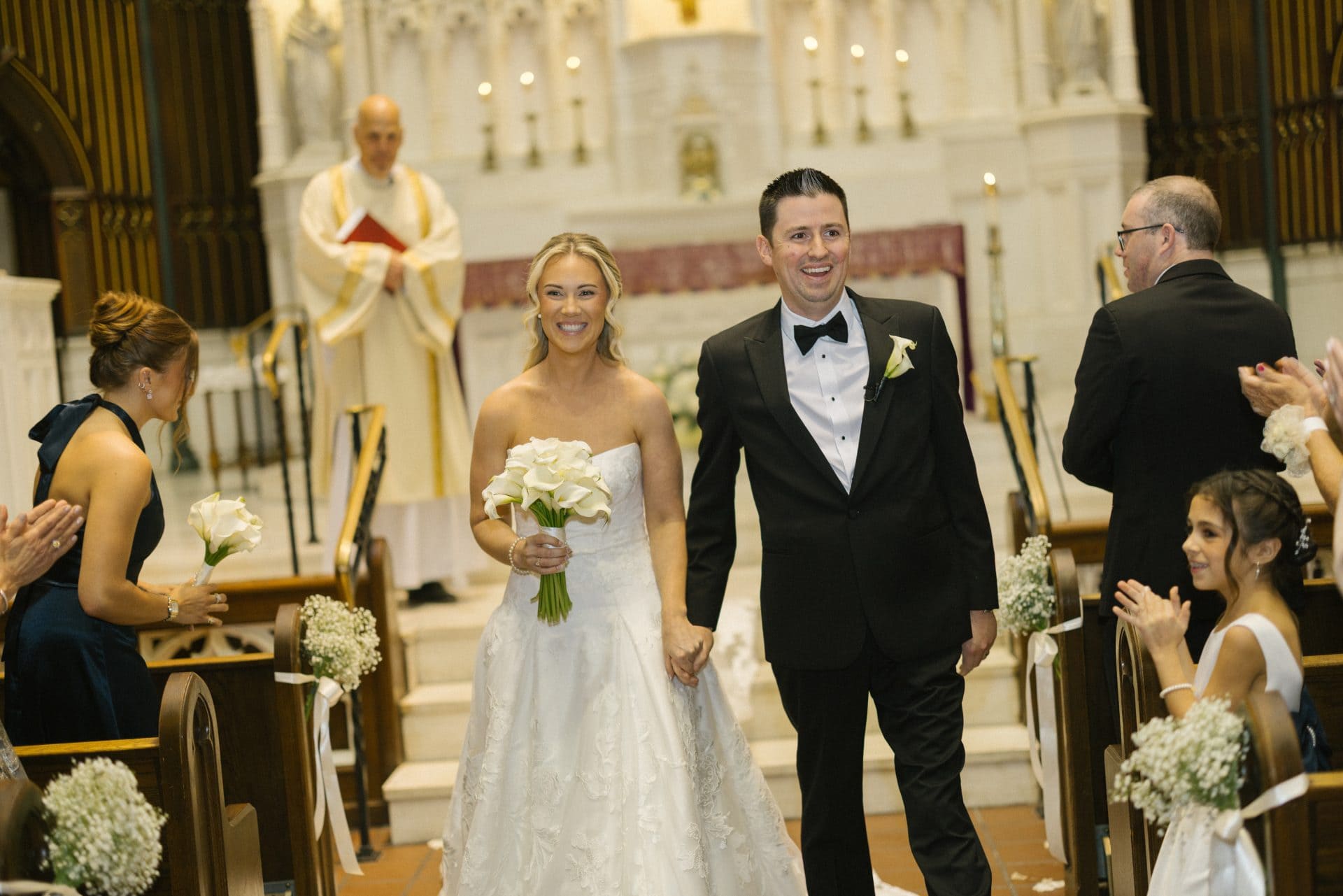 Bride and groom walking back up the aisle as guests applaud, South Jersey wedding photography