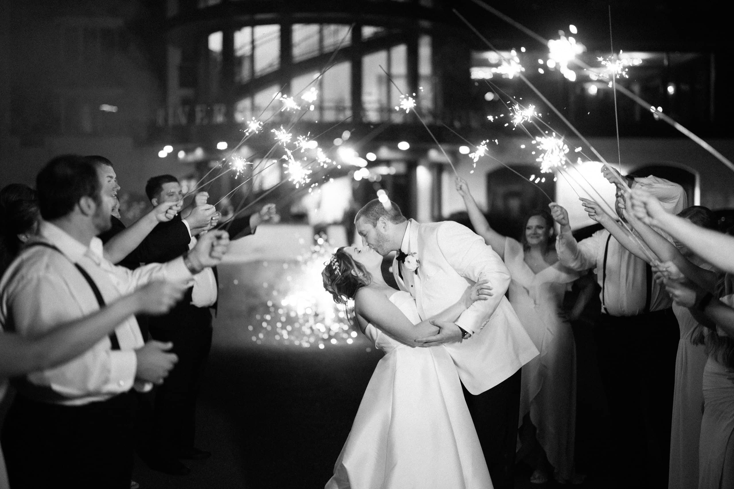 Nina and Rich kiss with fireworks behind them at their Lambertville Inn wedding