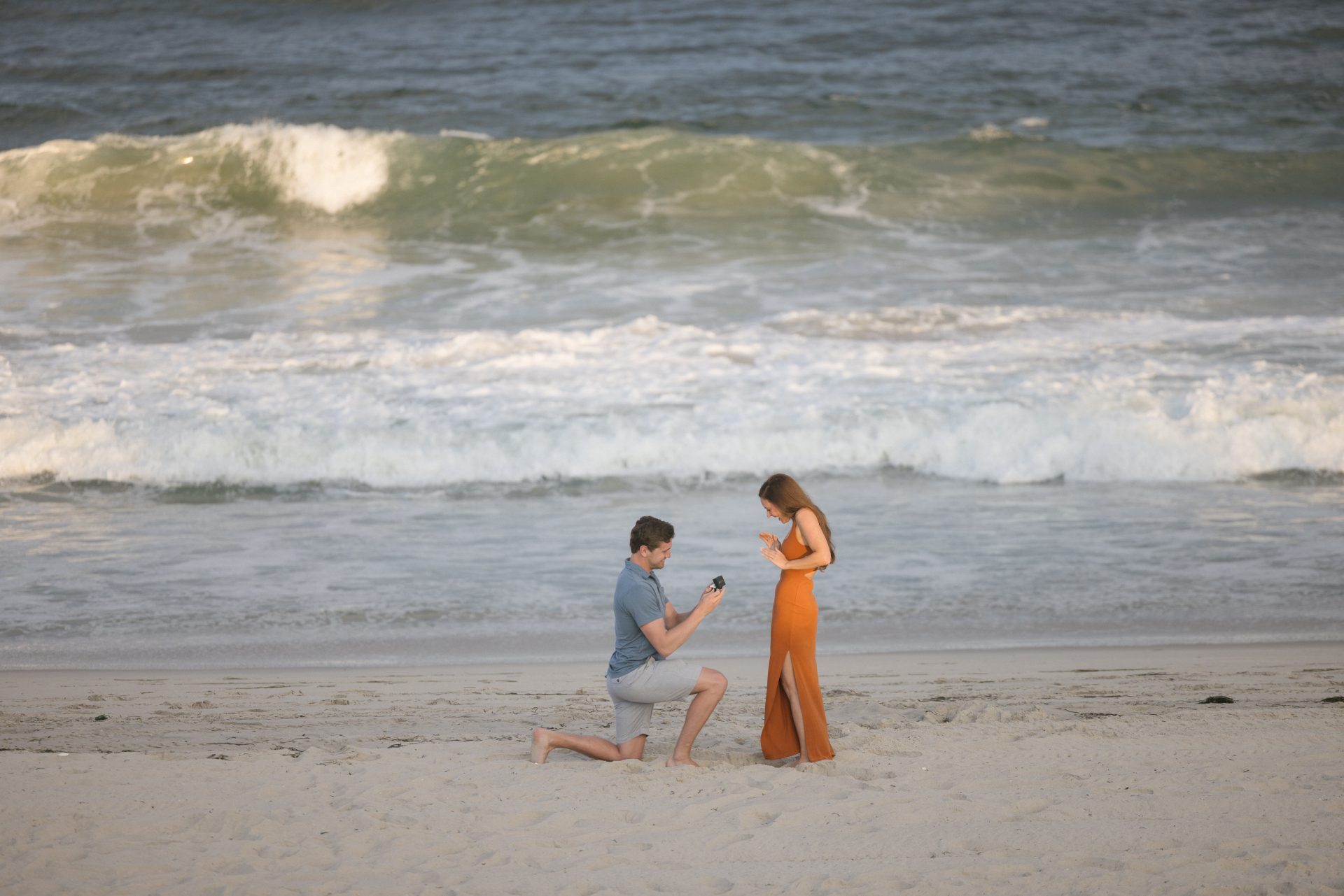 Couple sitting together on the beach in Brant Beach during a surprise proposal session on the Jersey Shore