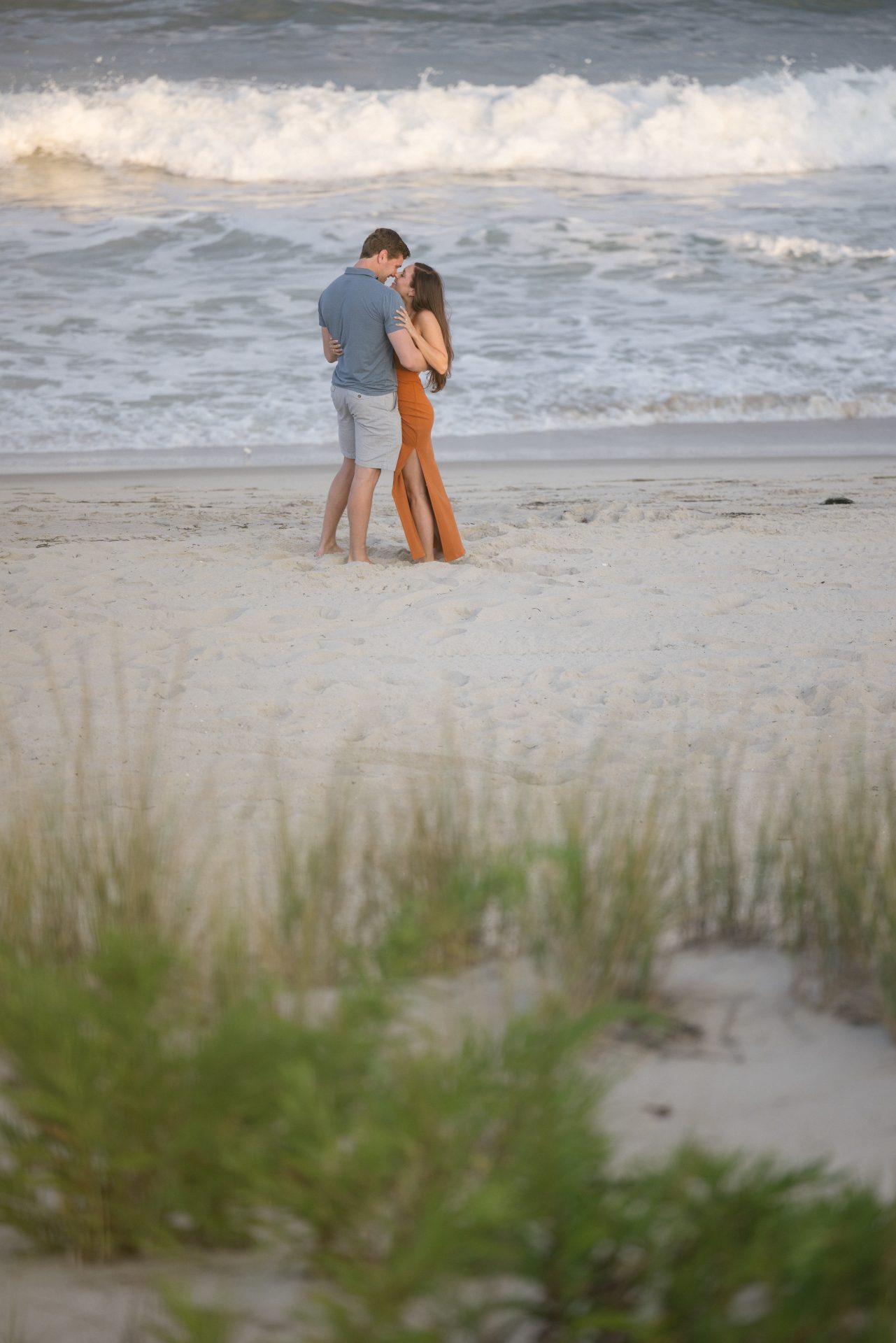 Man kneeling on the beach proposing at sunset in Brant Beach, LBI, NJ