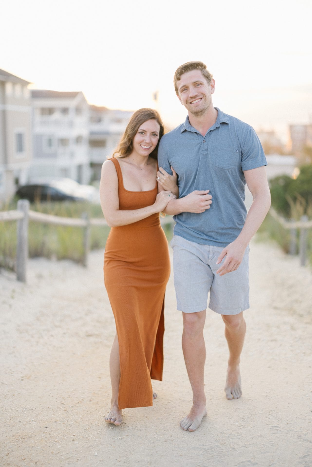 Smiling couple posing for engagement photos on the beach at Brant Beach, LBI