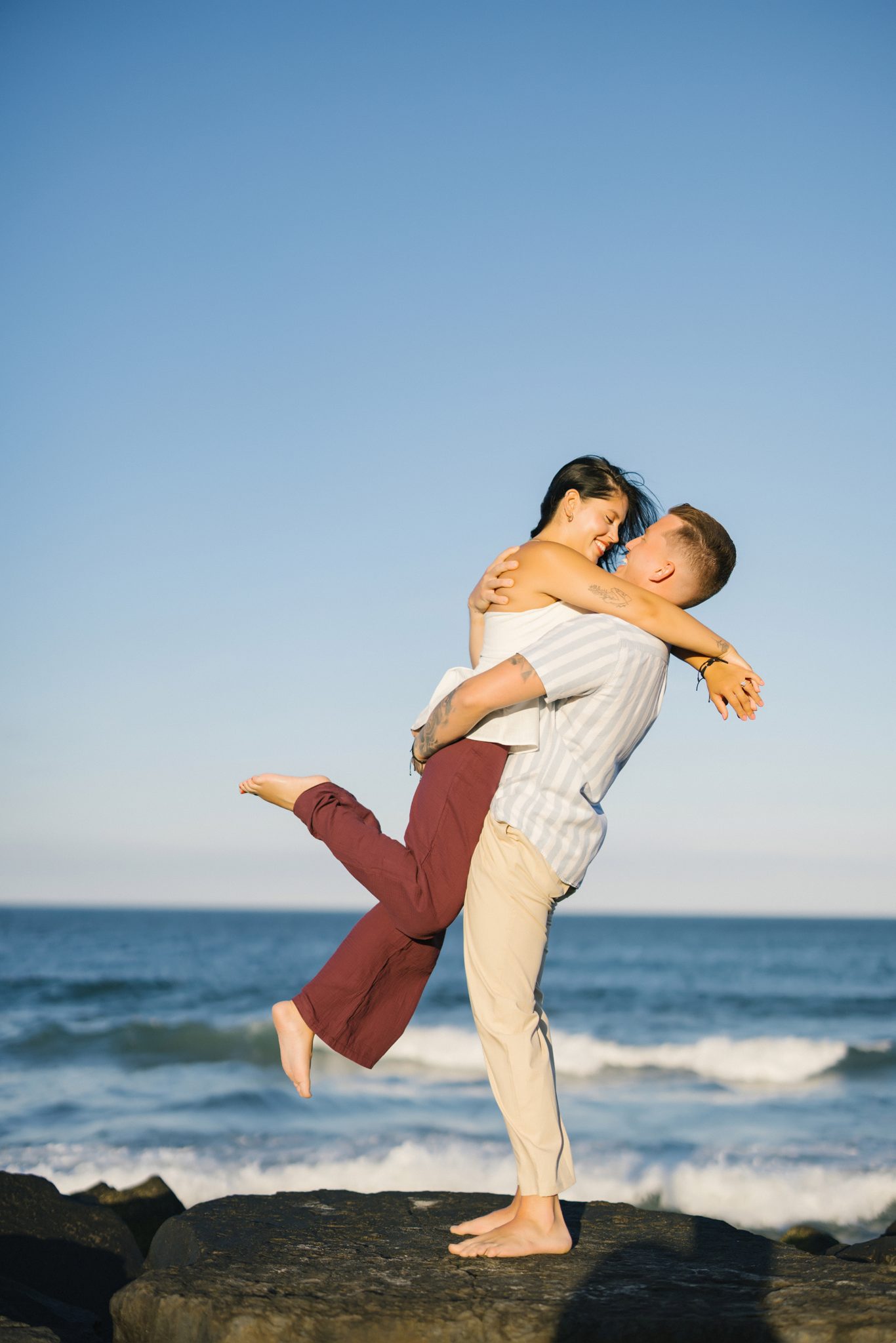 Groom to be lifting his fiancee on the beach in Asbury Park NJ at golden hour