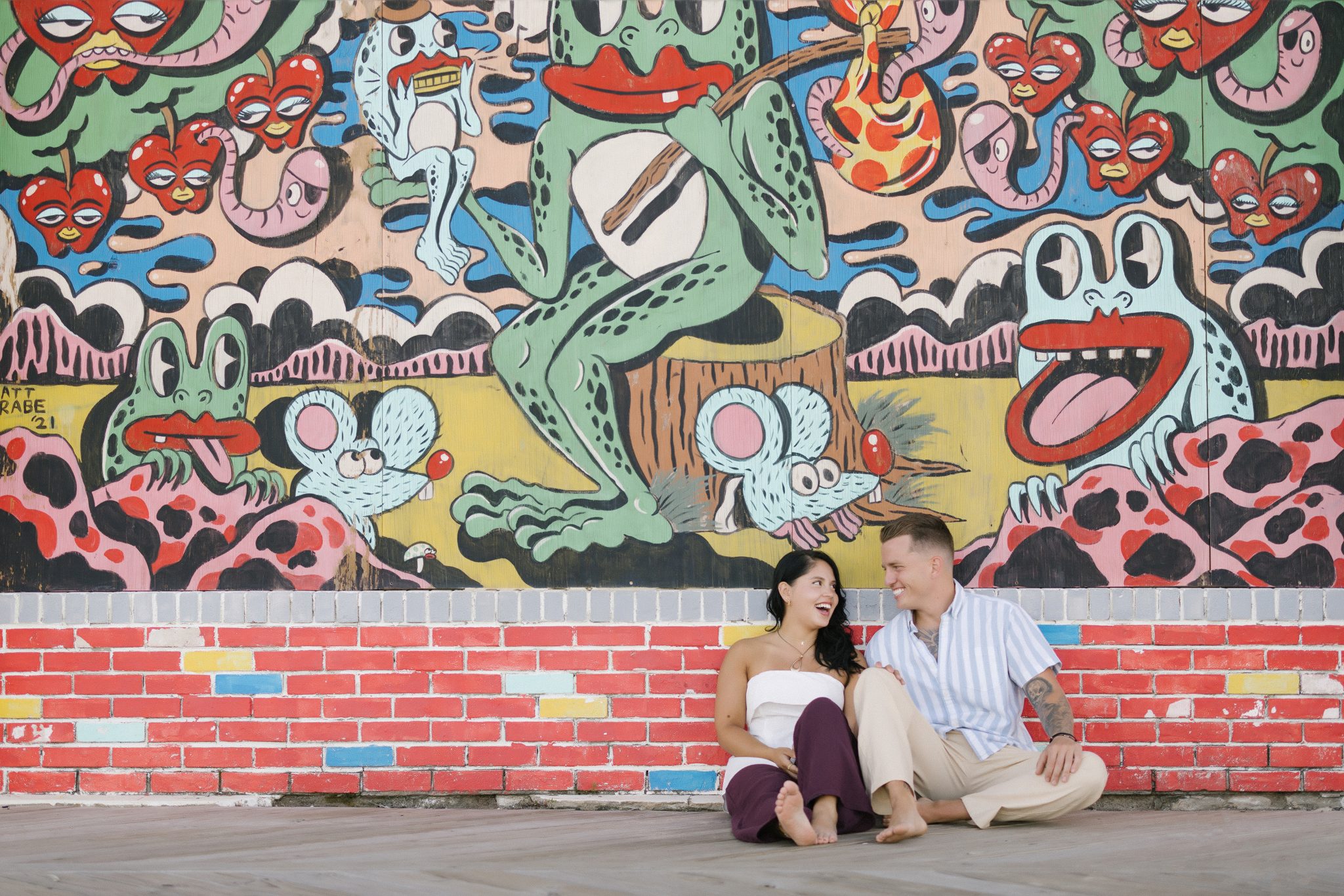Newly engaged couple photographed in front of a colorful Asbury Park mural