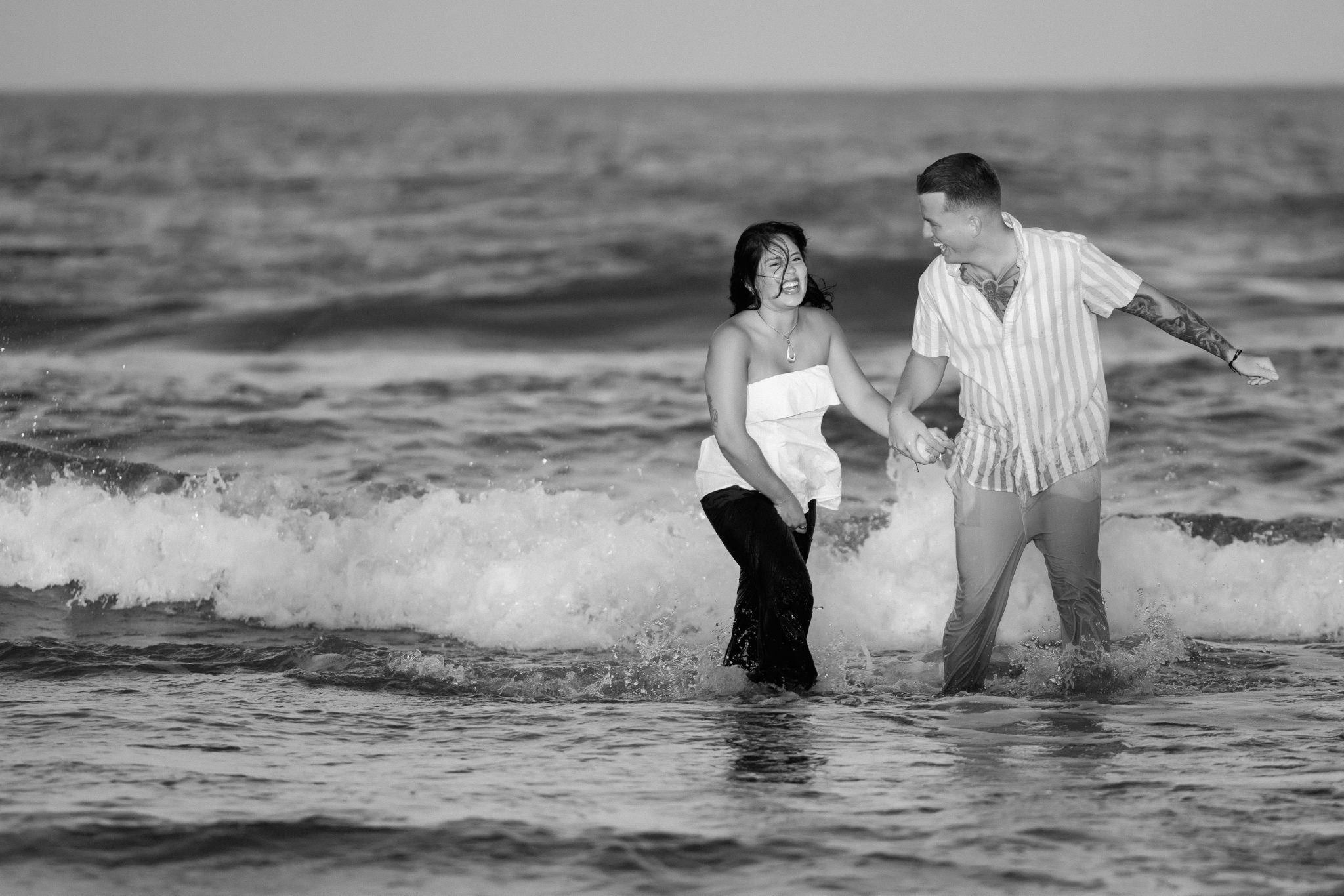 Newly engaged couple jumping in the ocean to celebrate their Asbury Park proposal