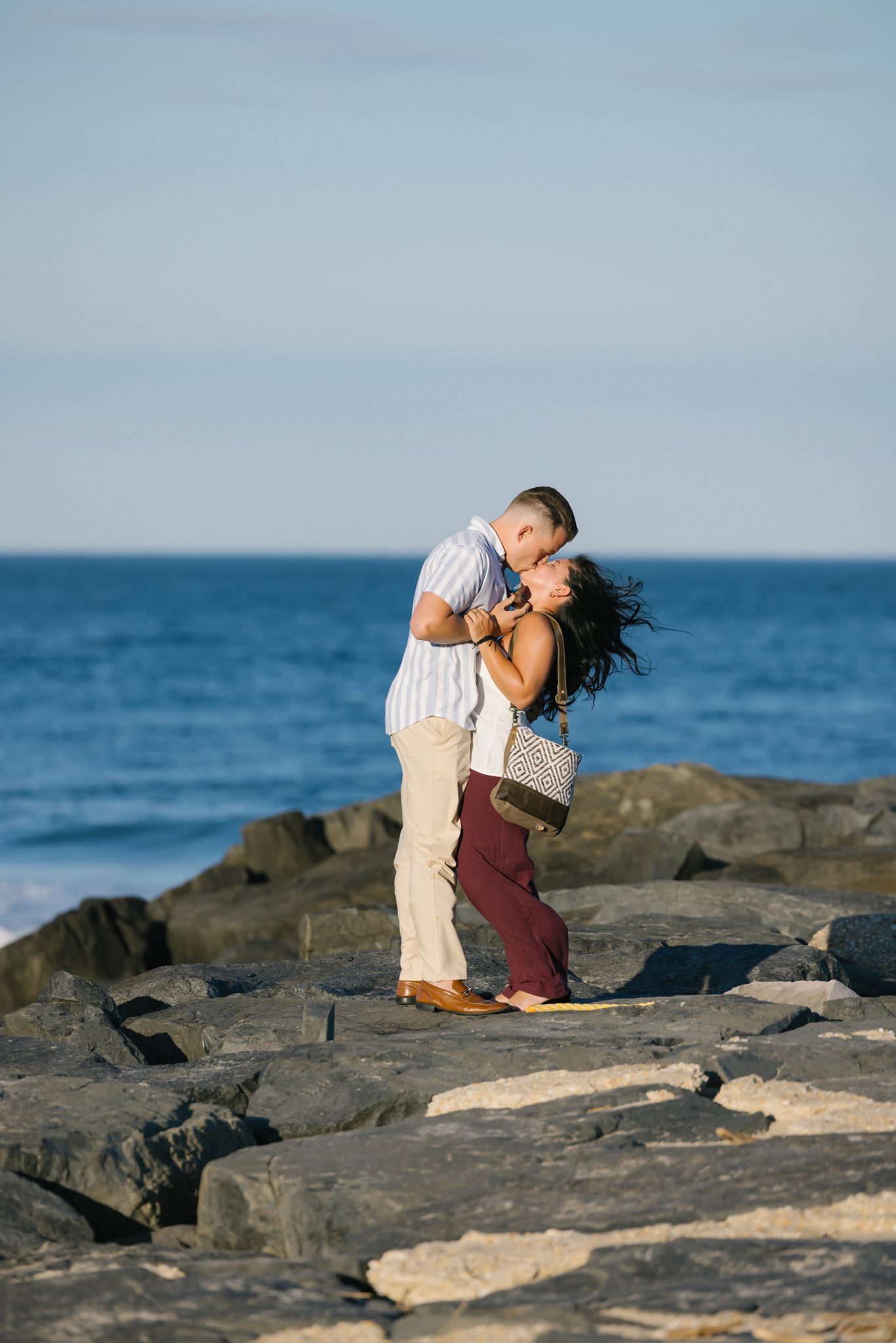 Couple embracing on the jetty after she said yes in Asbury Park NJ