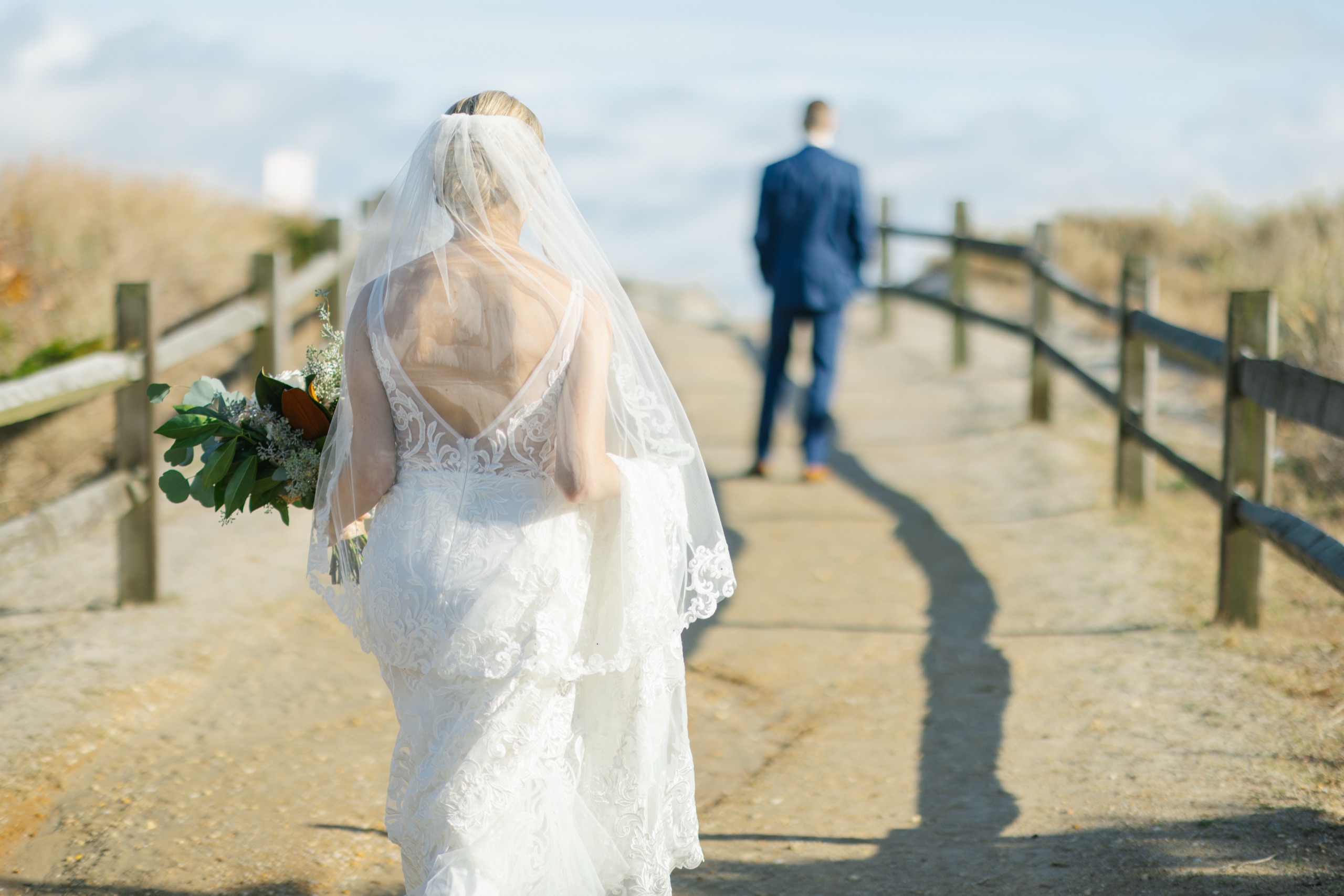 Bride walking up the dune crossing toward her groom for a first look at ICONA Avalon in Avalon NJ