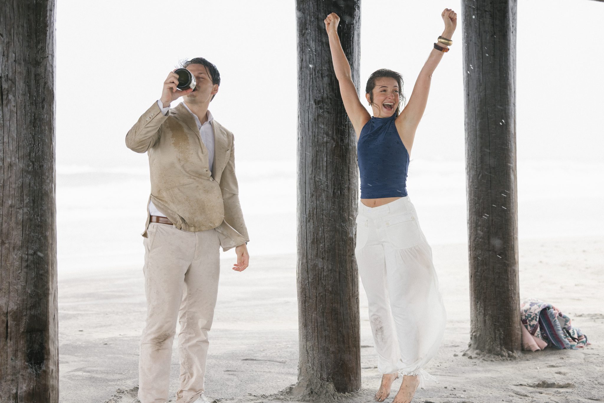 Newly engaged couple celebrating with champagne on the beach in Ocean City NJ