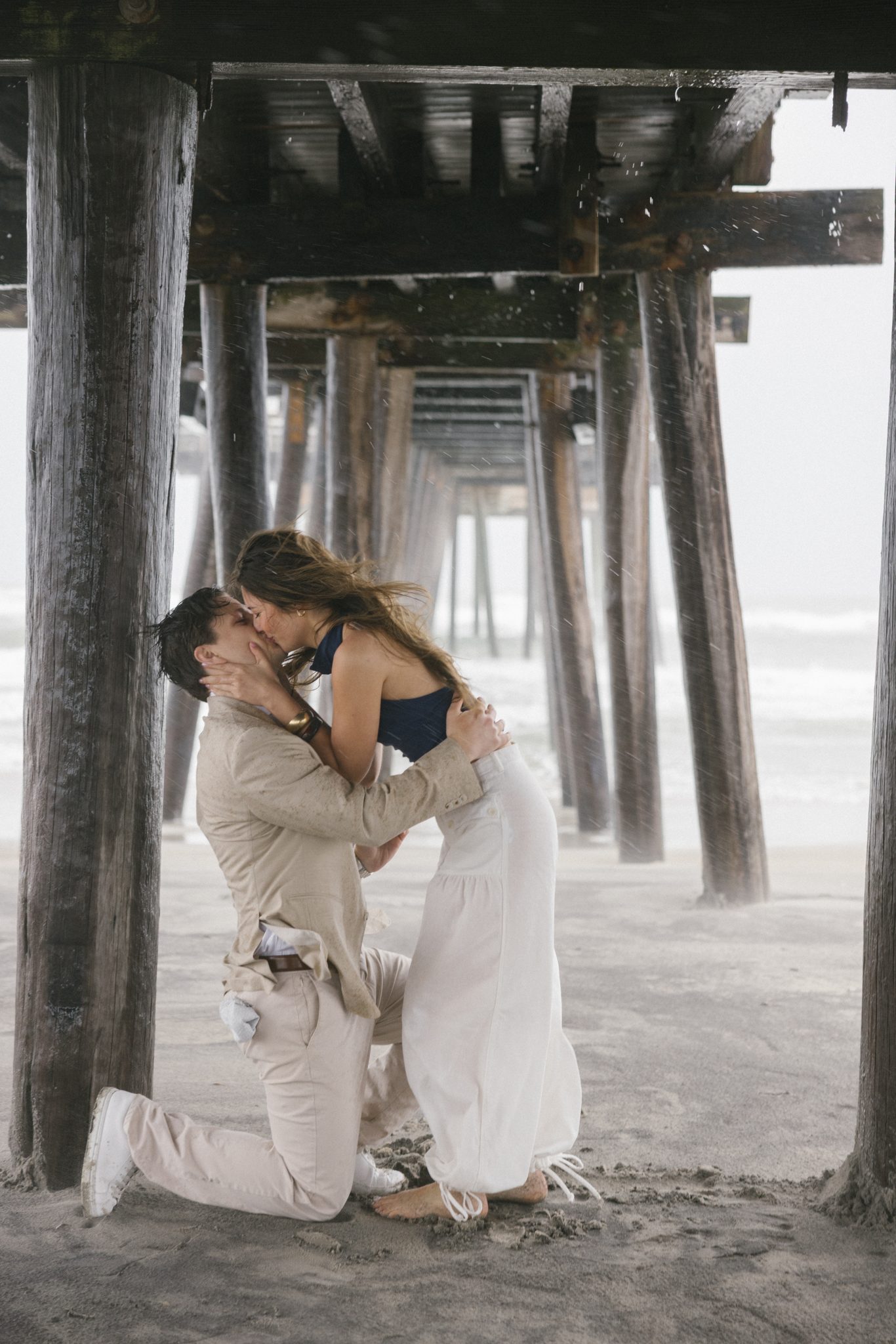 Couple embracing after she said yes under the fishing pier in Ocean City NJ