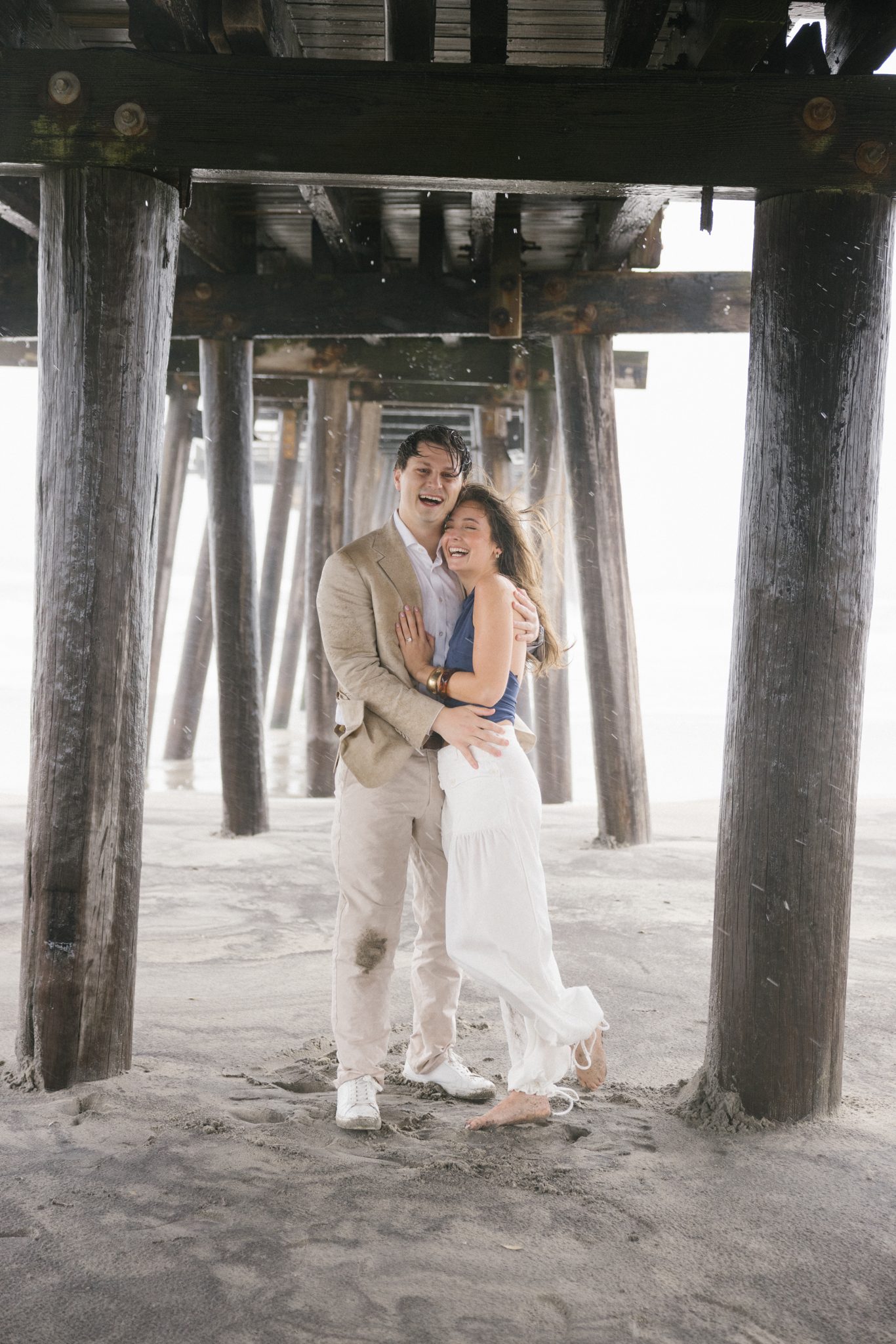 Newly engaged couple embracing in the rain in Ocean City NJ