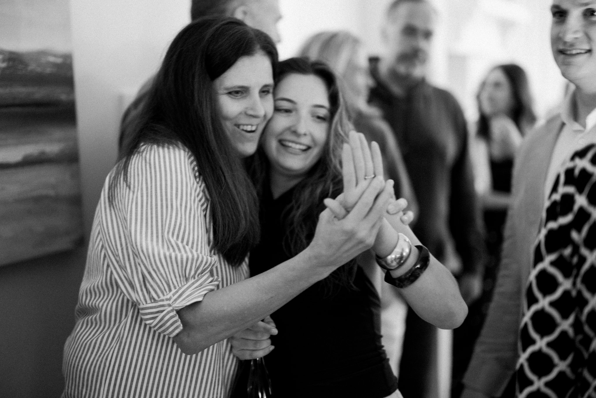 Black and white photograph of emotional hugs at the engagement party