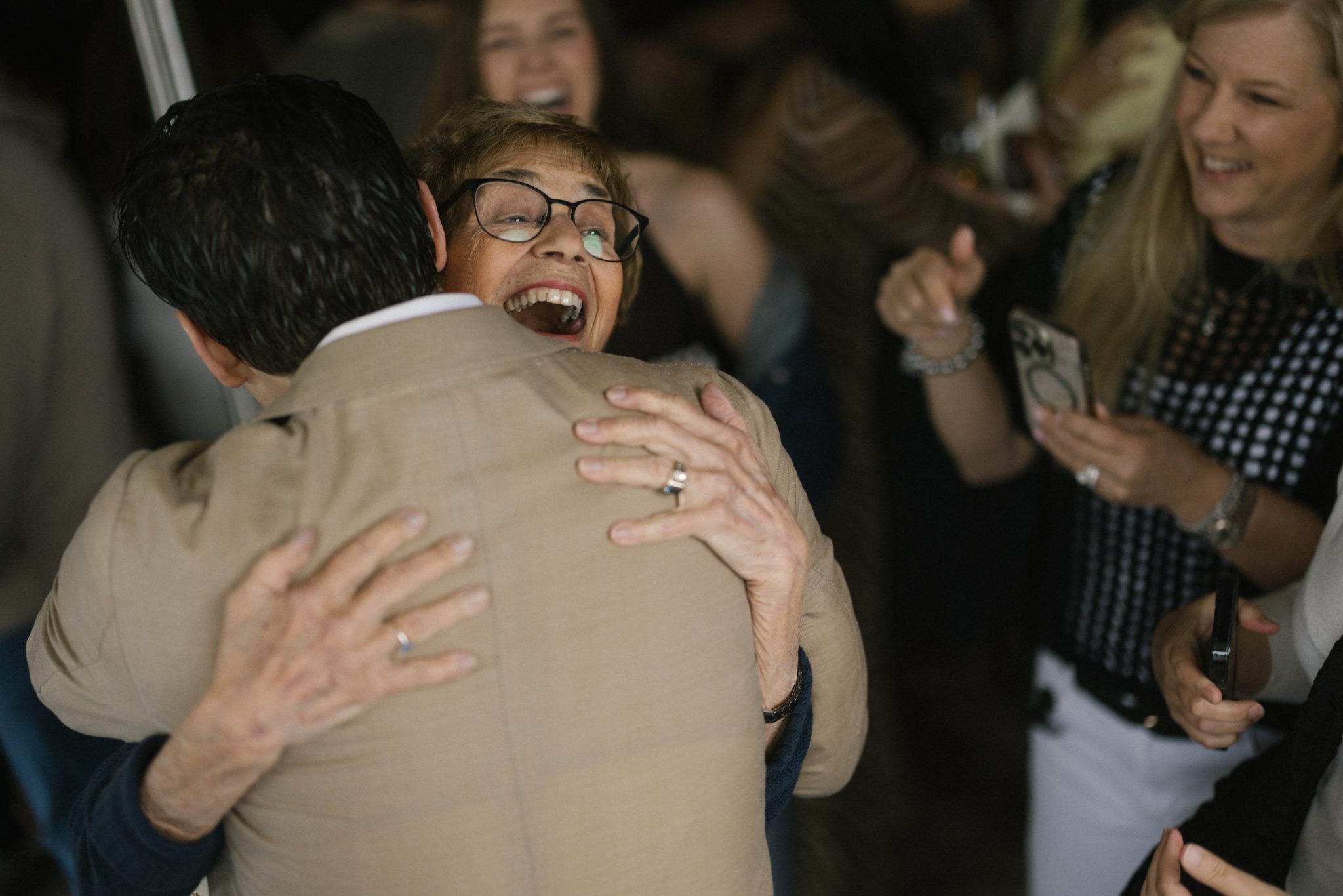 Laughing hug between guests at the engagement party