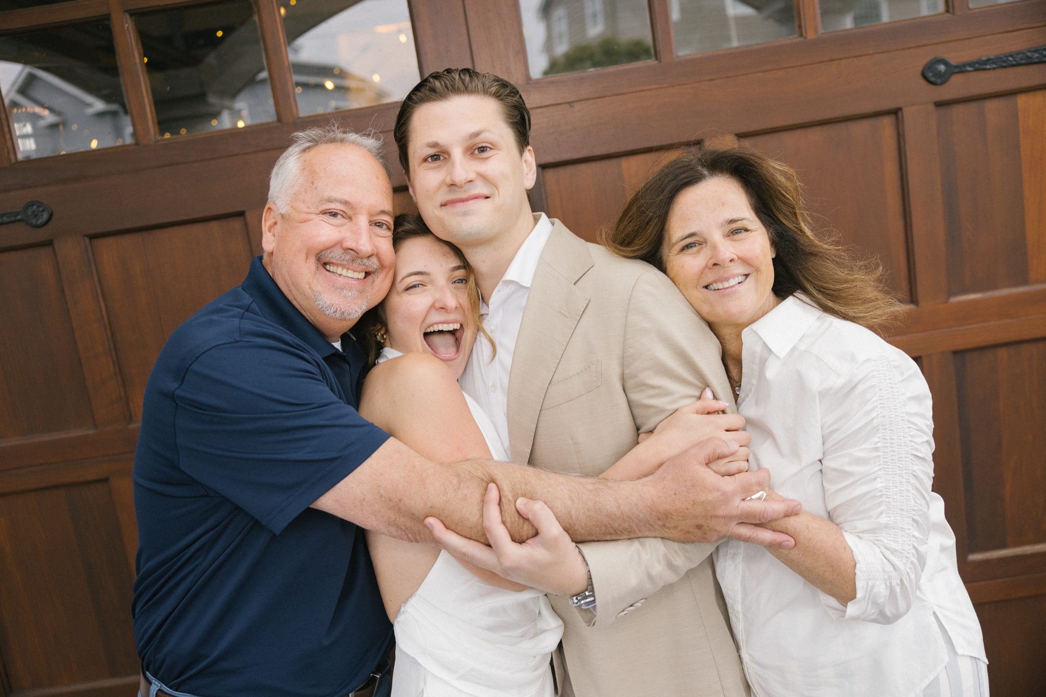 Parents embracing the newly engaged couple