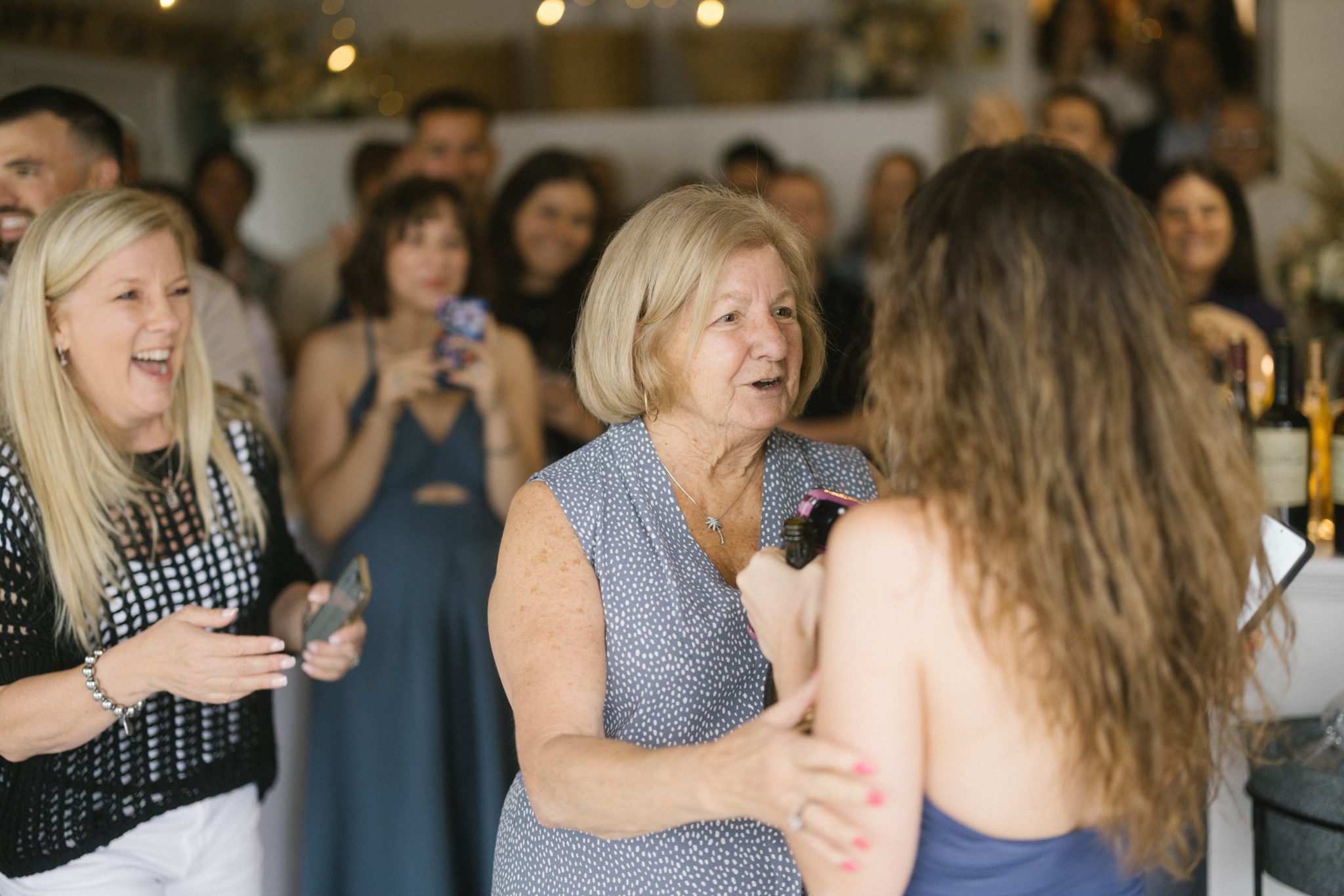 Guests cheering as the couple walks into their surprise engagement party