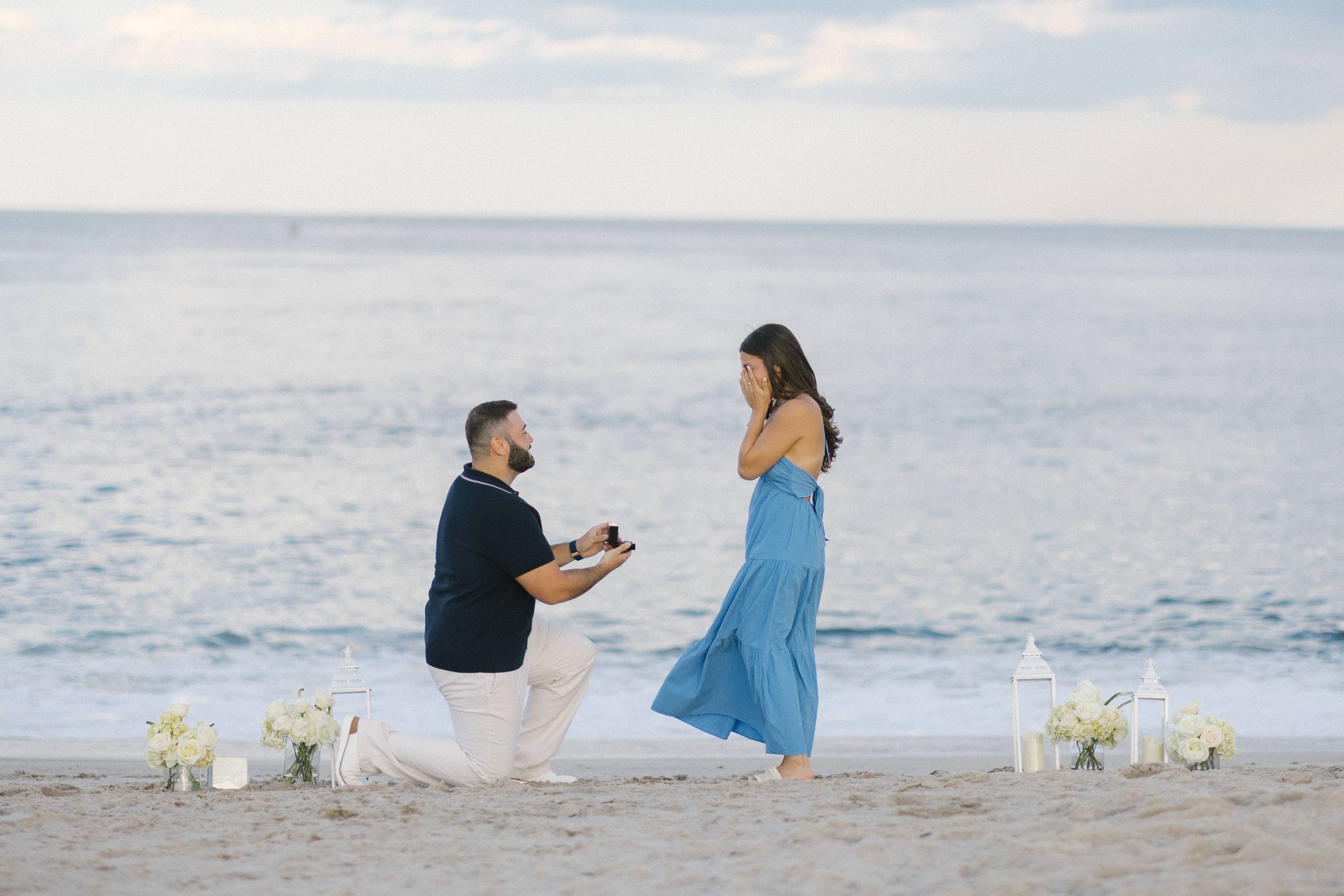 Anthony dropping to one knee to propose on the beach at the Manasquan Inlet in Point Pleasant Beach NJ