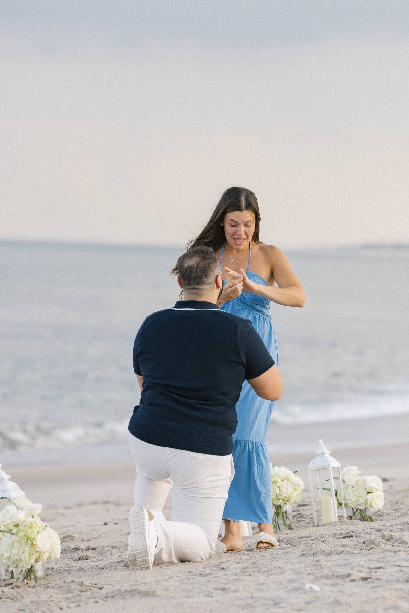 Juliette with her hands to her chest after saying yes at the Manasquan Inlet in Point Pleasant Beach NJ
