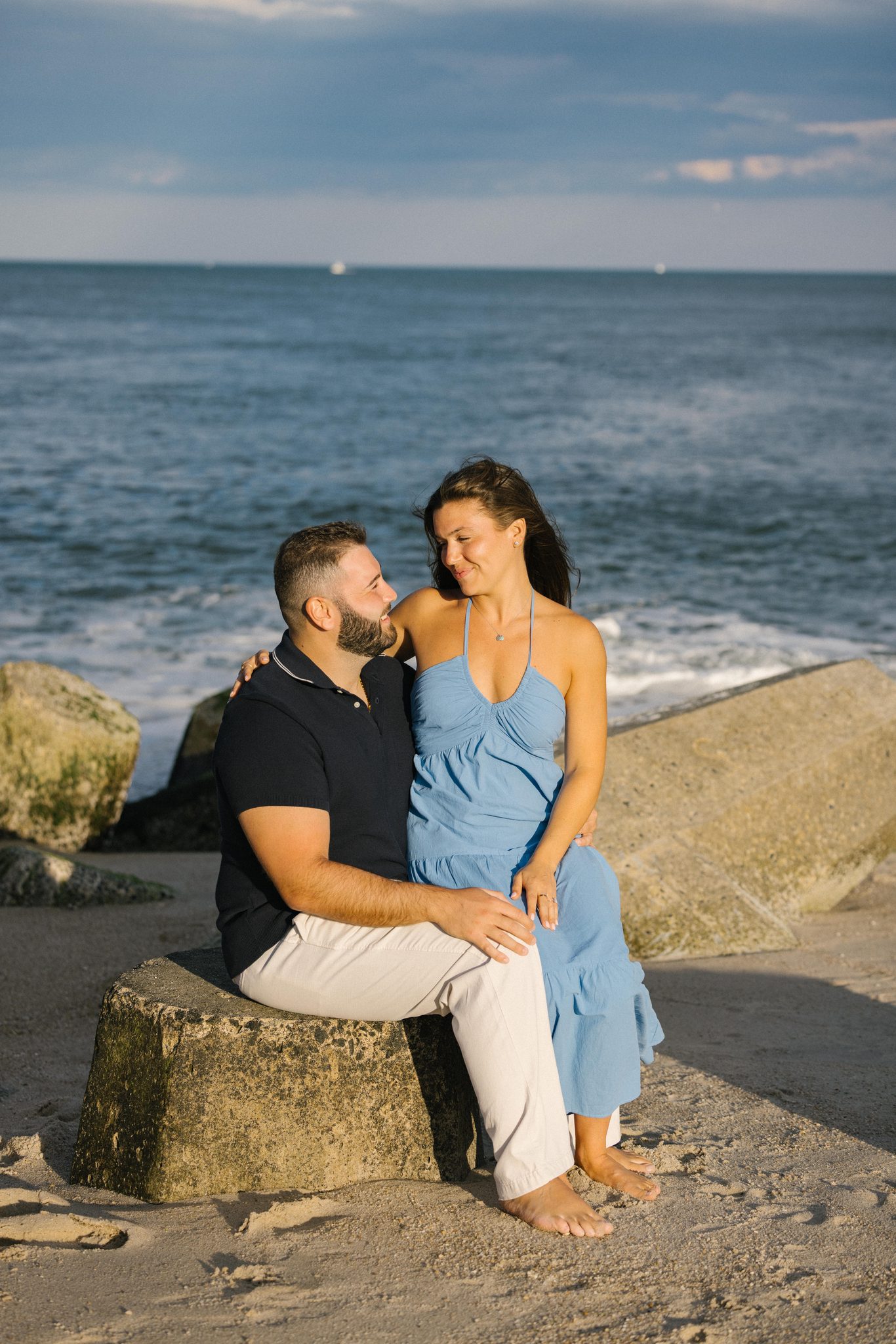 Anthony and Juliette seated on the jetty rocks after the proposal in Point Pleasant Beach NJ