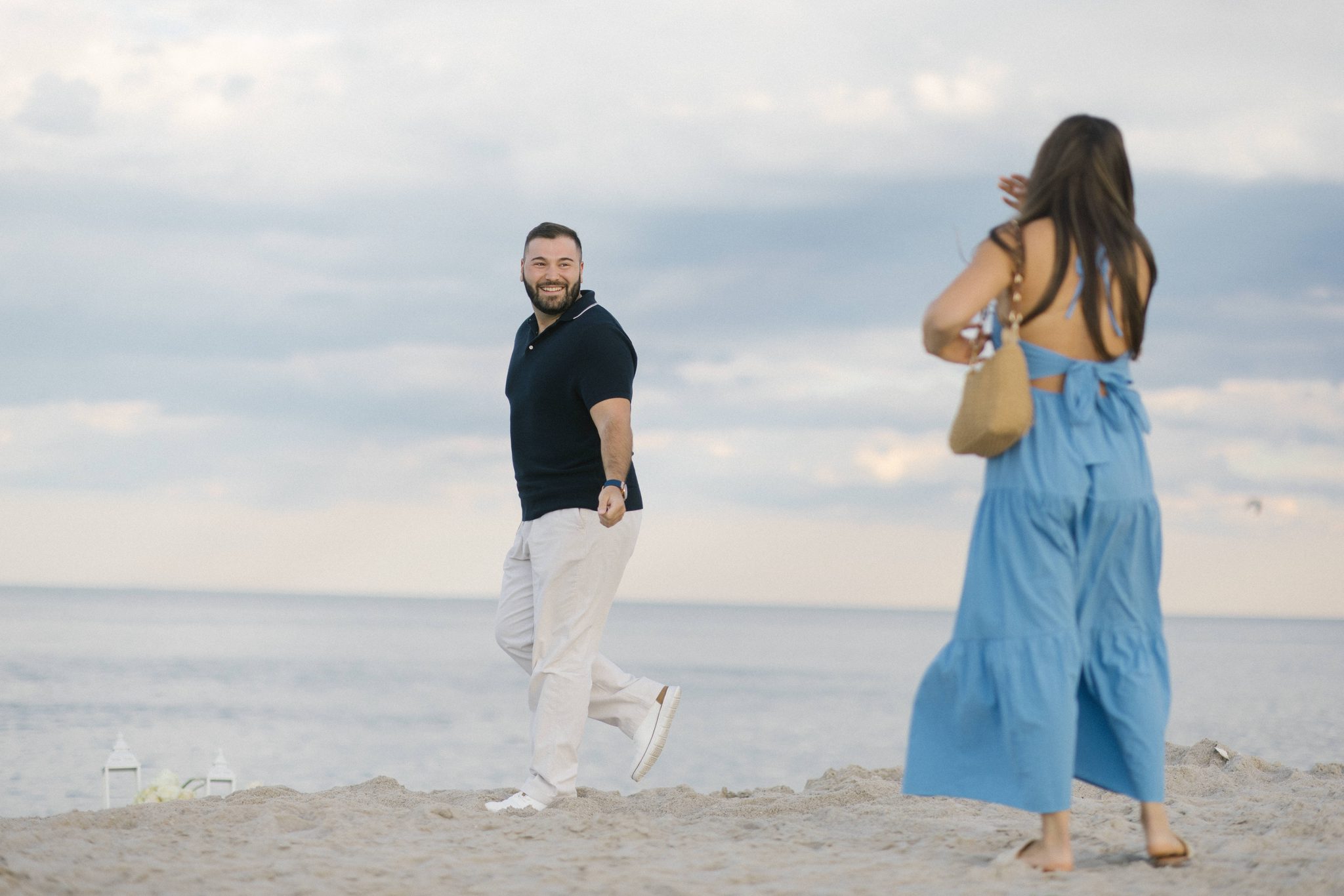Anthony walking Juliette down the beach toward the surprise proposal setup in Point Pleasant Beach NJ