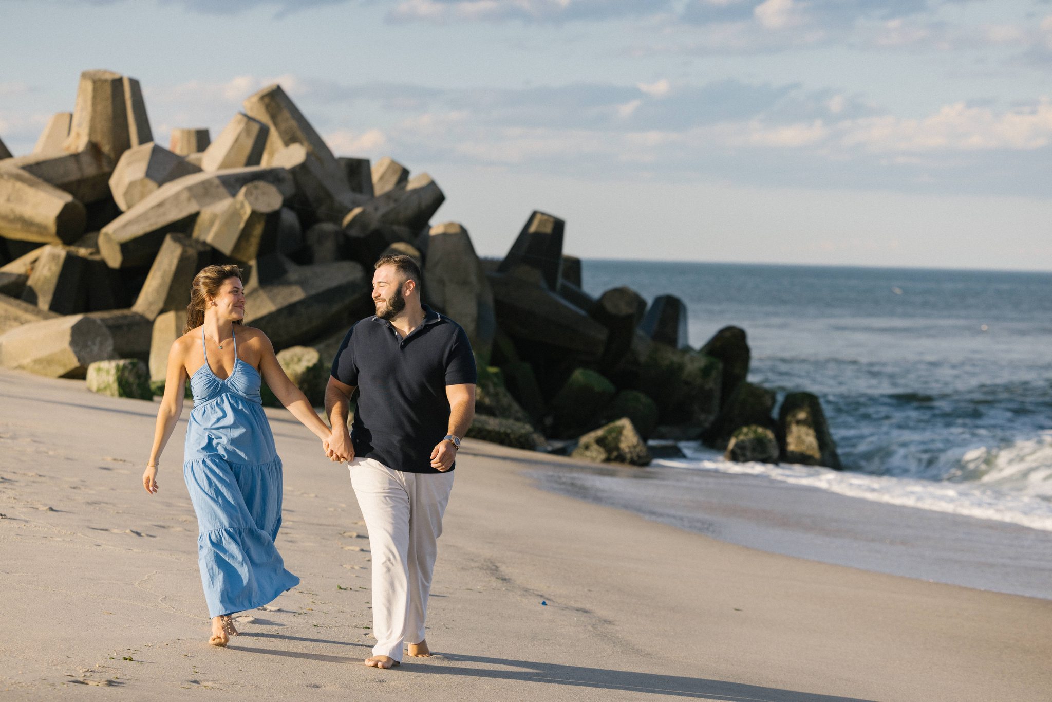 Anthony and Juliette walking the Manasquan Inlet jetty at golden hour in Point Pleasant Beach NJ