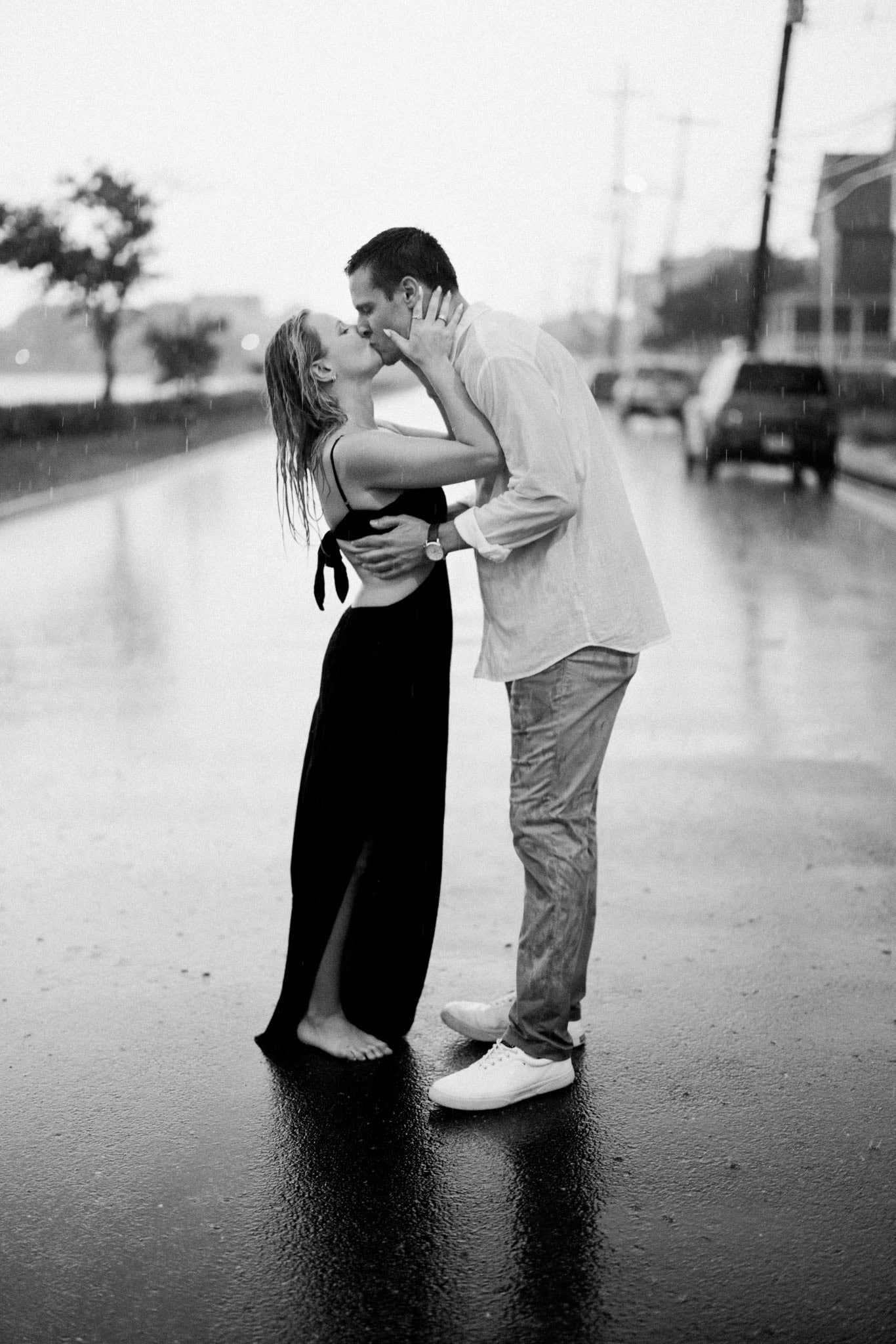 Black and white photo of a newly engaged couple dipping into a kiss in the rain in Bay Head NJ
