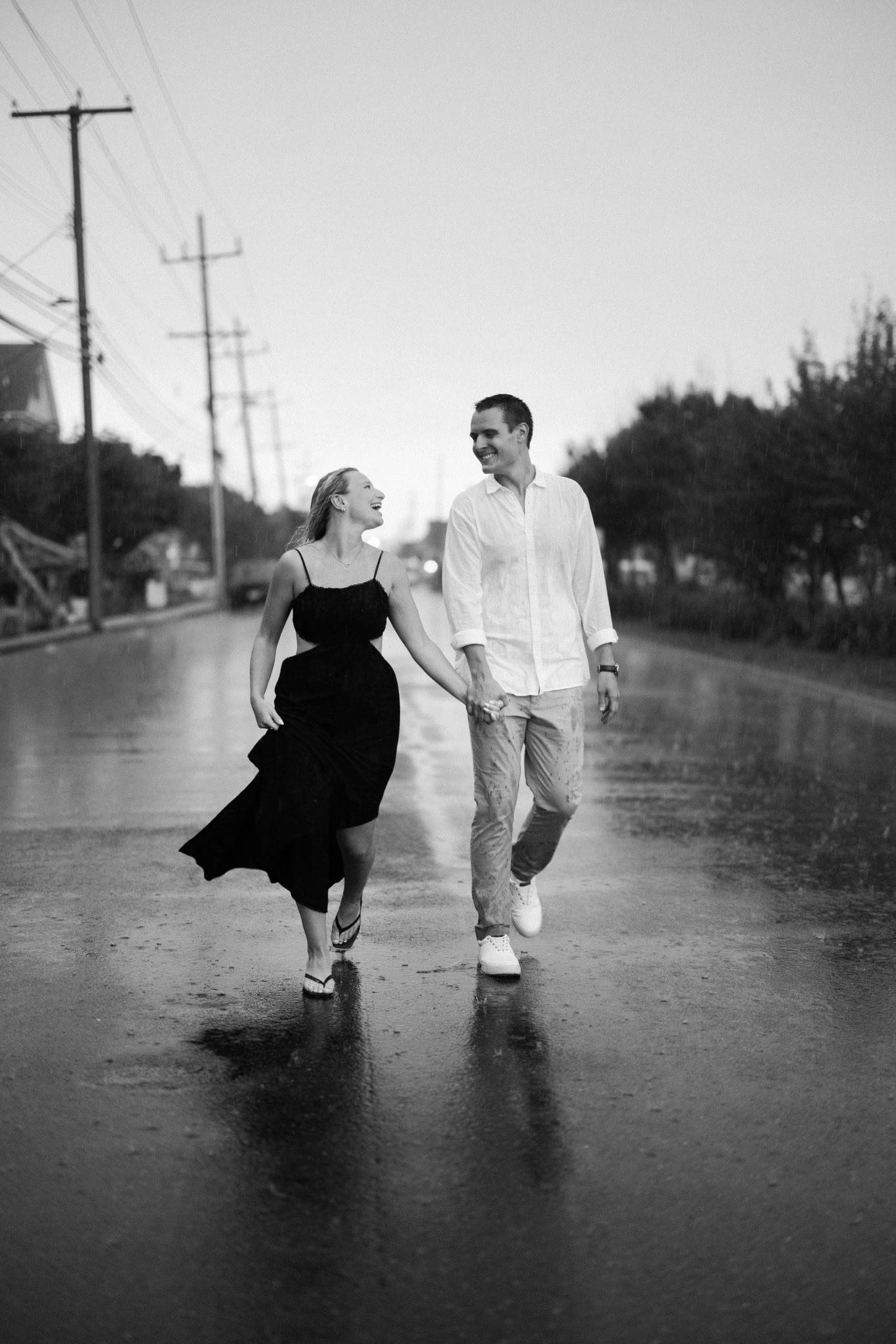 Black and white photograph of a couple walking in the rain after a Bay Head NJ proposal