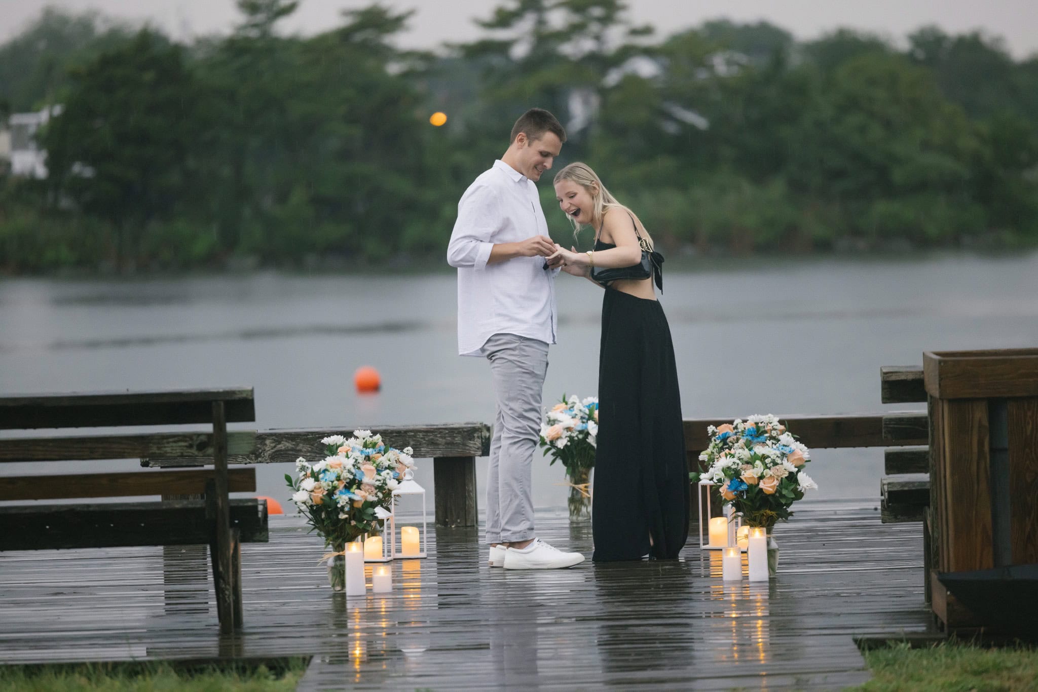 Just engaged couple embracing on a flower lined dock on Twilight Lake in Bay Head NJ