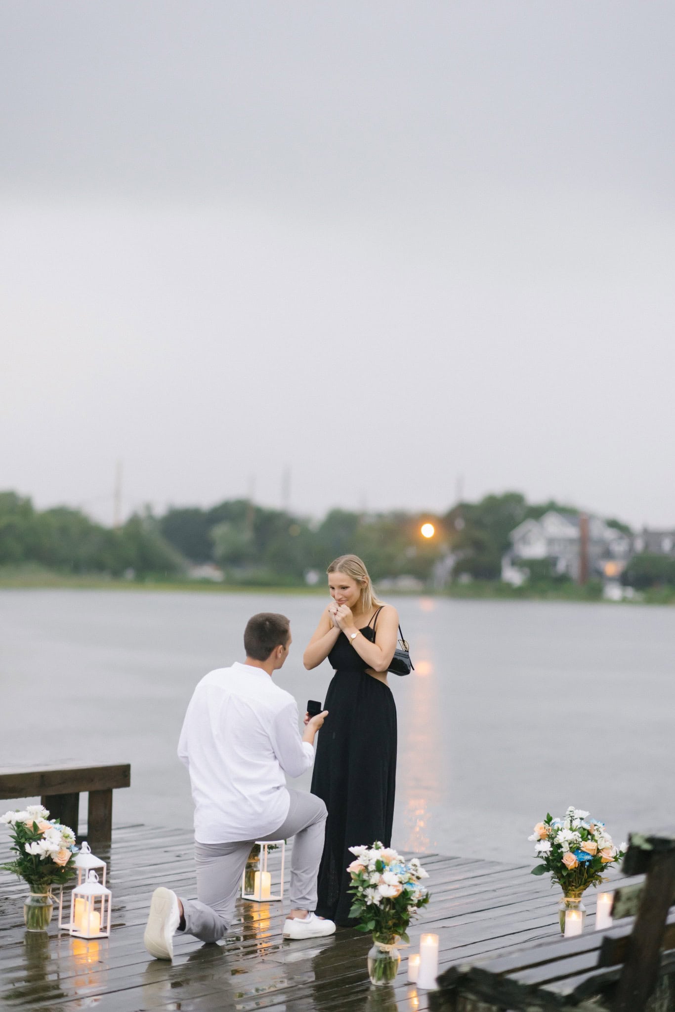 Woman's emotional reaction as her partner proposes on a rainy dock in Bay Head NJ