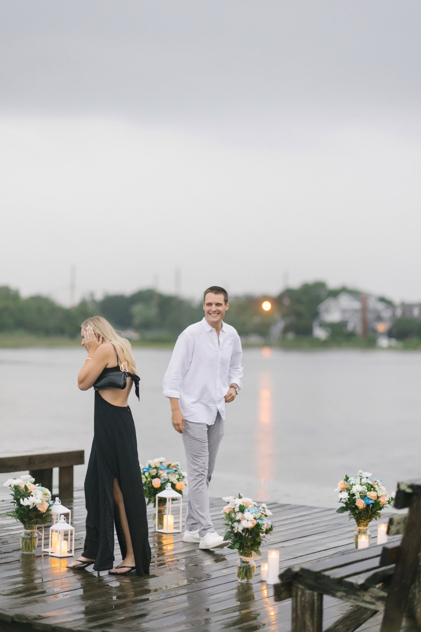 Candlelit dock lined with flowers on Twilight Lake at dusk during a rainy Bay Head NJ surprise proposal