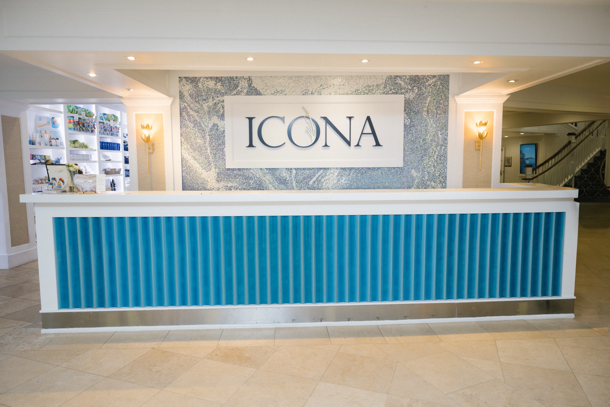 Newly renovated front desk and lobby at ICONA Avalon in Avalon NJ with the ICONA sign and teal reception counter
