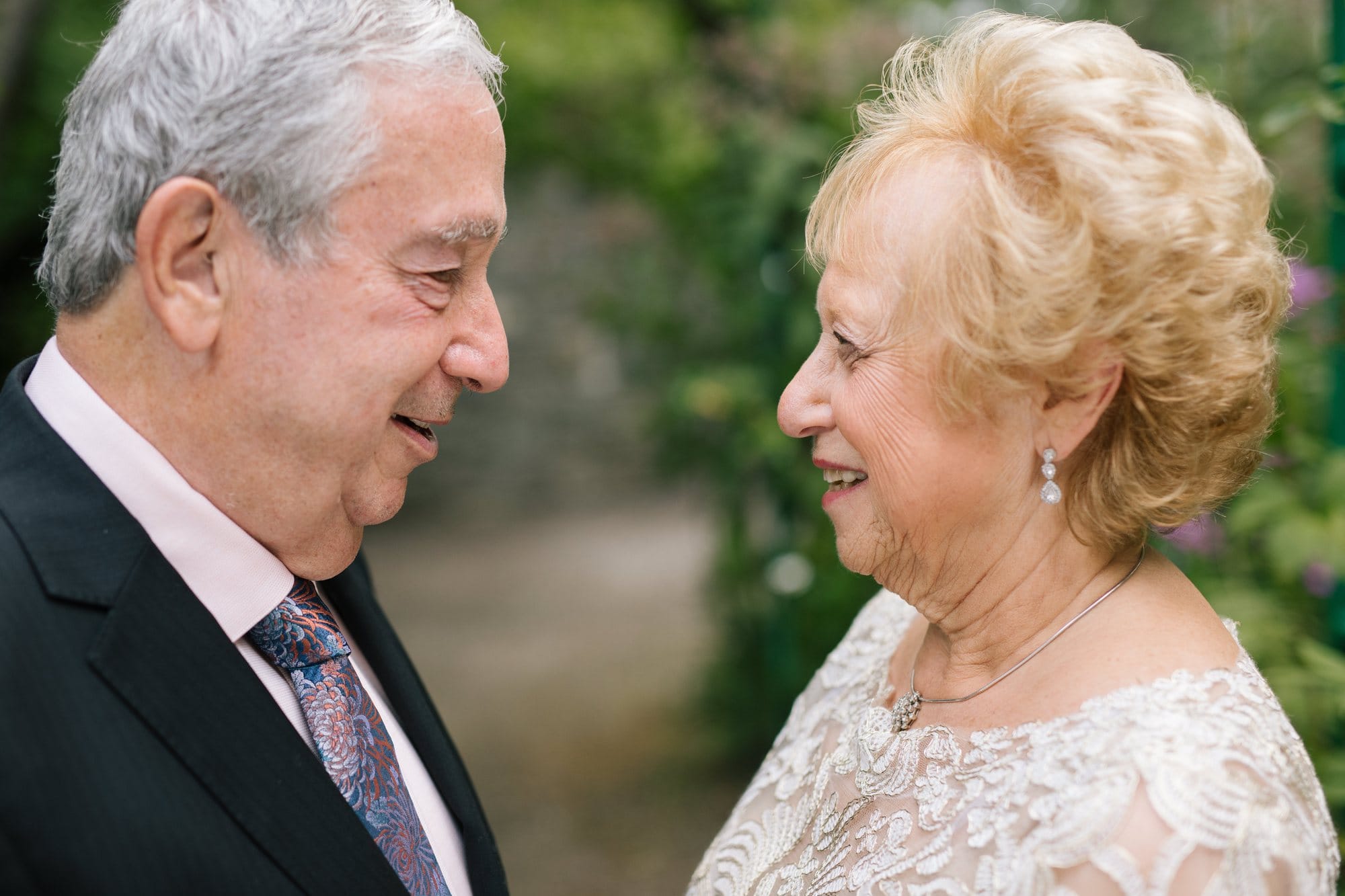 A longtime couple smiling at each other during a milestone anniversary session in New Jersey