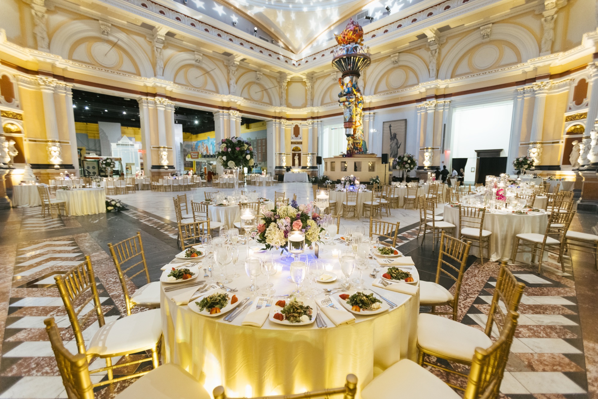 Please Touch Museum wedding reception in Hamilton Hall with gold chiavari chairs and Statue of Liberty torch
