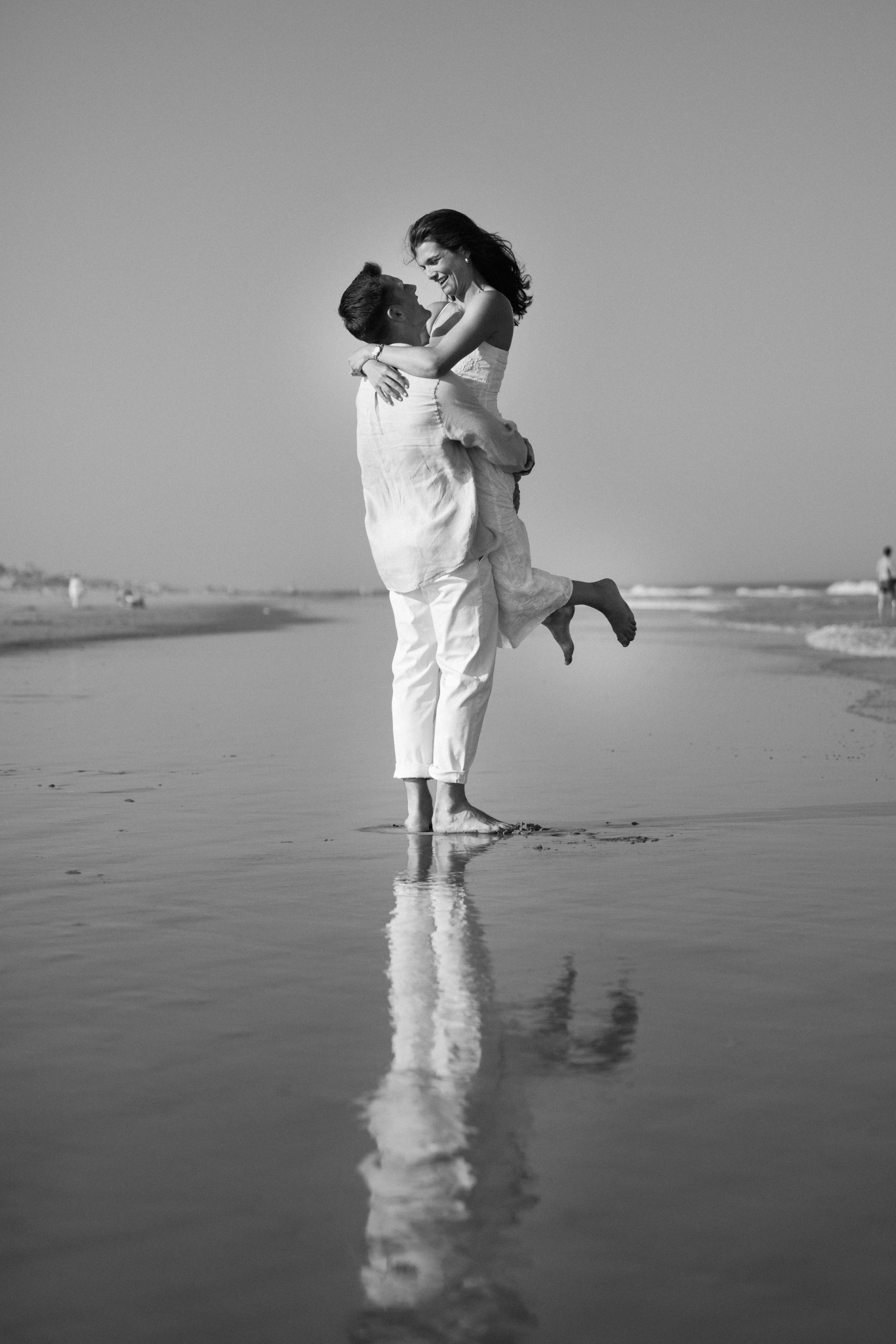 Black and white photograph of Chris lifting Katie by the water in Stone Harbor, New Jersey